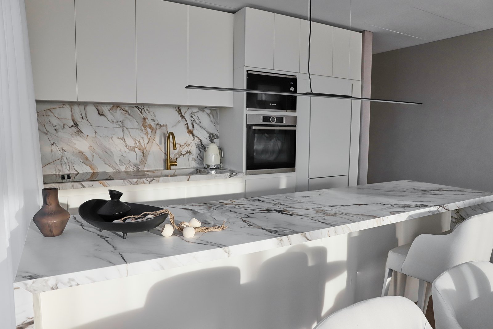 Cocina moderna con isla de mármol y muebles blancos — proyecto OBRA TORRES LINK, por MARCELO MAZZA, en Puerto Madero