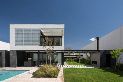 Fachada moderna con pileta y jardín integrado — proyecto CASA SD28, por GMARQ, en Buenos Aires