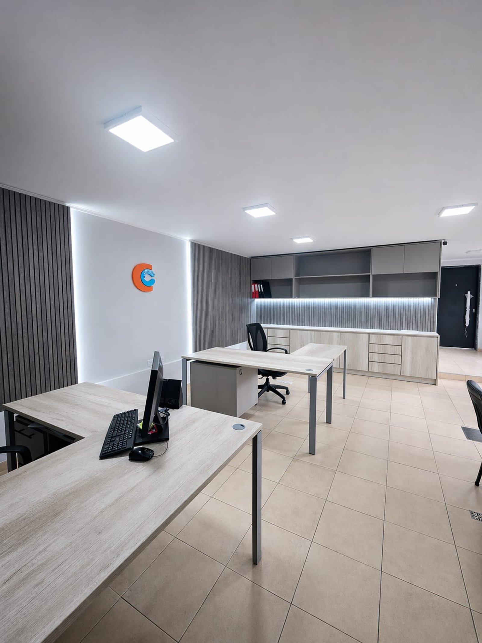 Oficina moderna con escritorios, sillas ergonómicas y luz indirecta — proyecto Grupo CICCO, por uniKKo Estudio de Diseño, en Mar del Plata