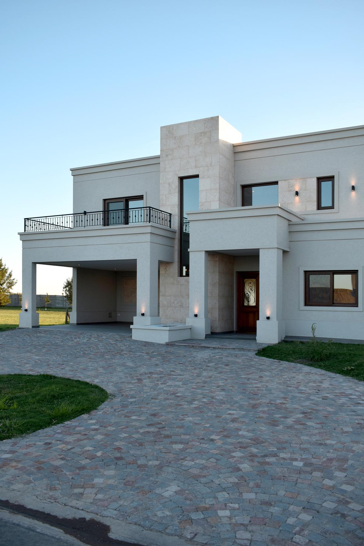 Fachada moderna con detalles en piedra y balcón — proyecto Casa TLS816, por EZ architects, en Canning