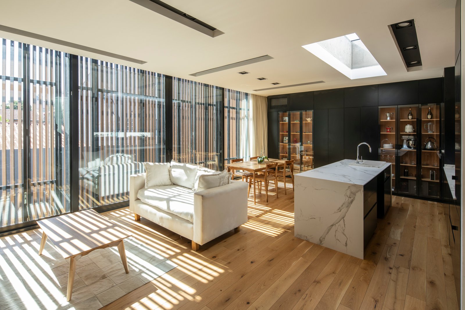 Living comedor moderno con isla de cocina y ventanales amplios — proyecto Casa MECHA, por Grupo CRBN, en B1712 Castelar