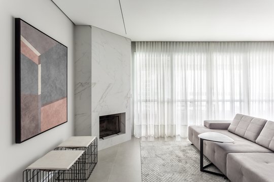 Living moderno con chimenea integrada y sofá seccional gris, mucha luz natural — proyecto Apartamento LN, por Boscardin Corsi Arquitetura