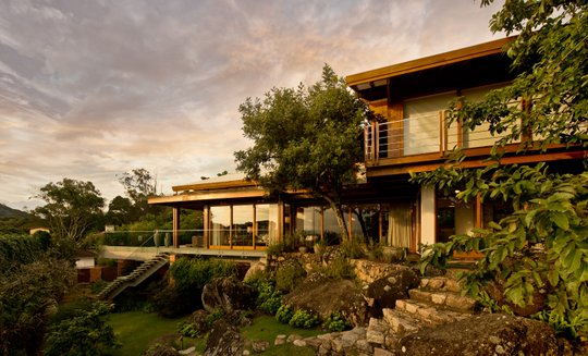Casa contemporánea con madera, terrazas y jardín al atardecer — proyecto Casa A.L., por Ruschel Arquitetura e Urbanism
