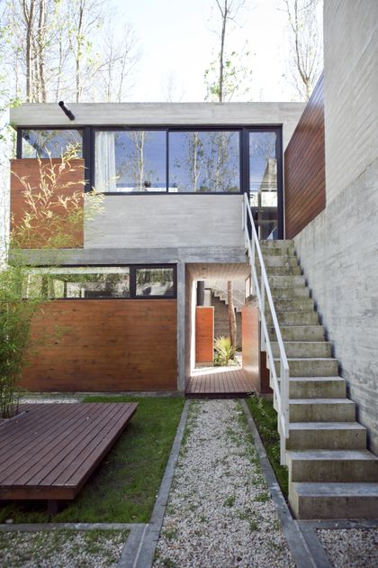 Casa contemporánea de dos plantas con fachada mixta hormigón y madera — proyecto Conjunto Las Gaviotas, por Luciano Kruk