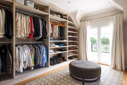 Amplio vestidor con muebles modulares, puf central y balcón con vista — proyecto Casa Tortugas , por Estudio Du , en Tortugas Country Club