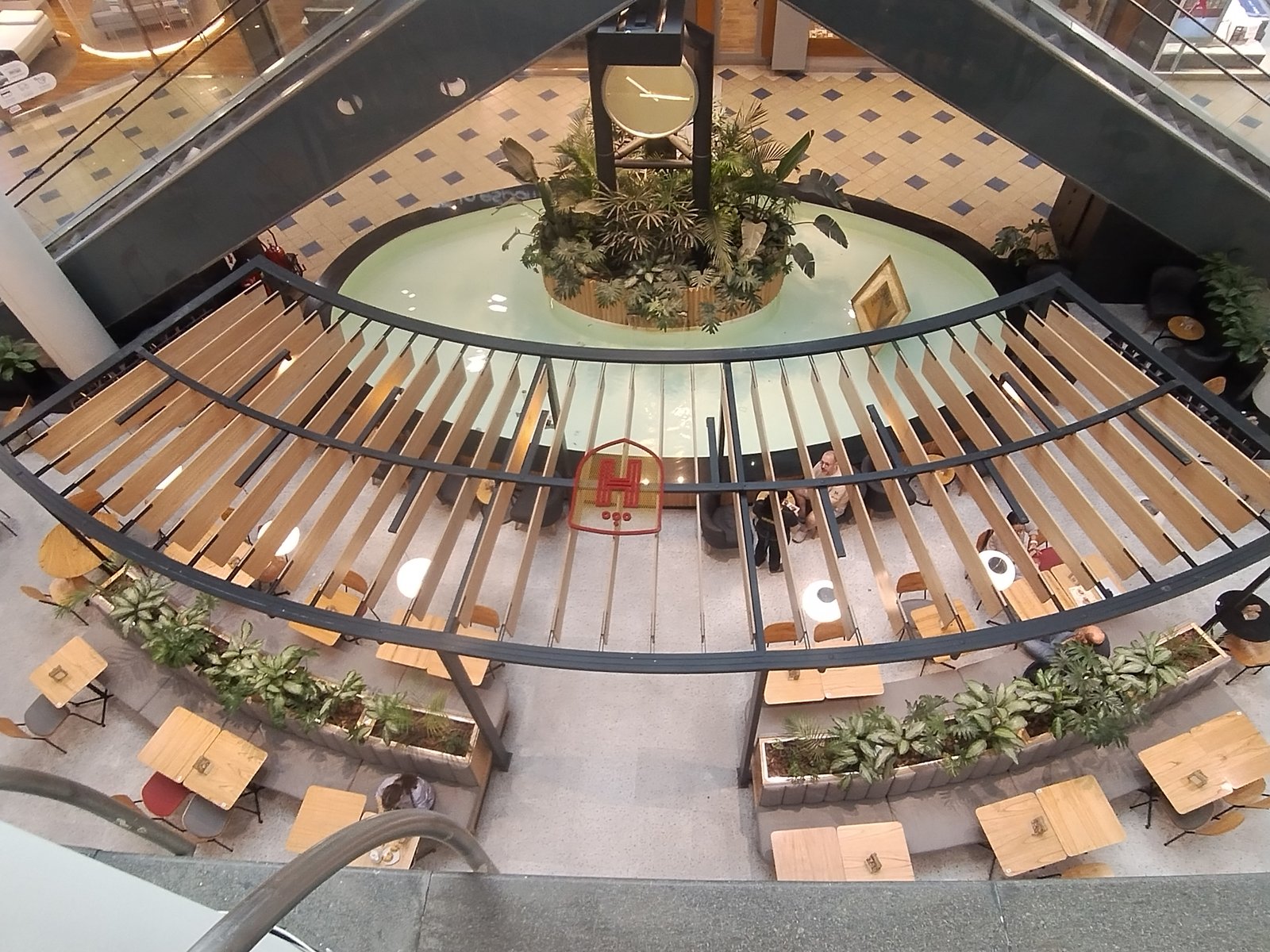 Espaço comercial com fonte central e assentos curvos — projeto Havanna Plaza Oeste Shopping, por COMOTTO - SOMMER  - ARQUITECTOS, em Blvd. Juan Manuel de Rosas 658