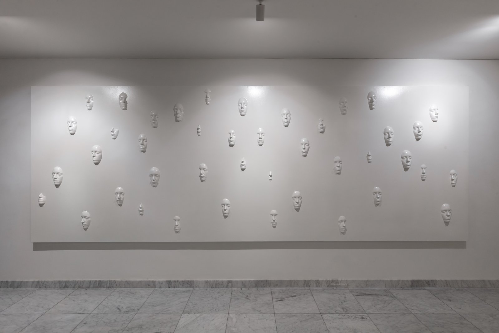 instalación de rostros blancos en pared minimalista — proyecto Figueroa Alcorta | Rhinoplasty meets art, por Ren Studio, en Palermo Chico