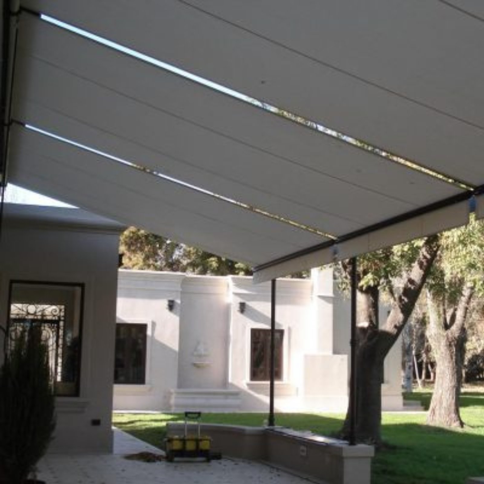 Patio moderno con toldo retráctil y mobiliario de exterior — proyecto Toldo Deslizante, por ToldosYa