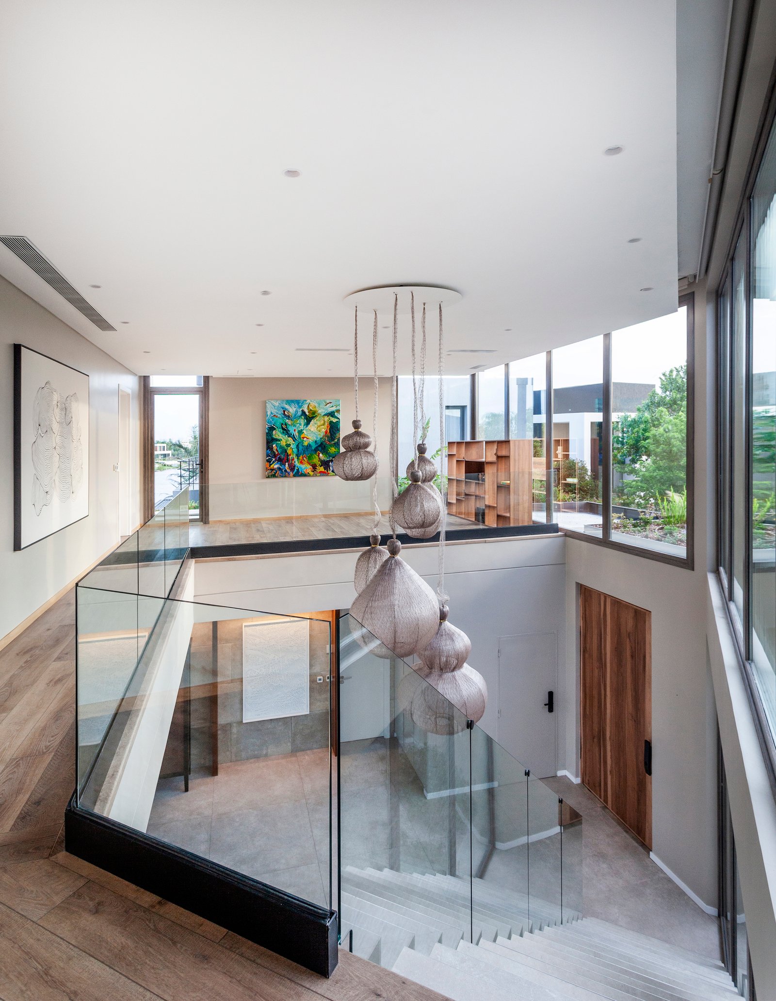 Escada flutuante moderna com luzes orgânicas e corrimão de vidro — projeto CASA M40, por A'PRIMA - Arquitectura Sustentable, em Unnamed Road