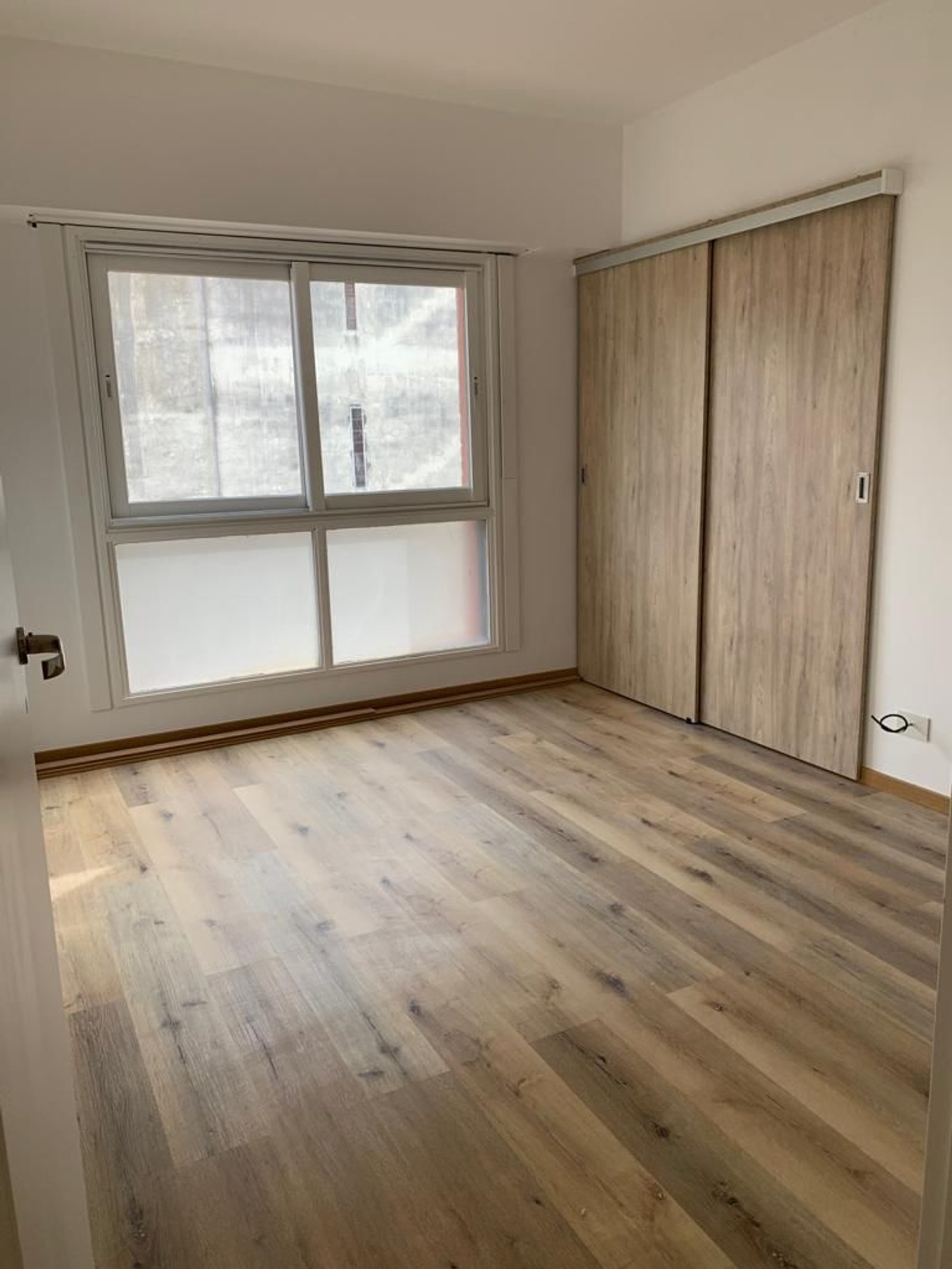 dormitorio moderno con piso de madera y placard — proyecto Pisos Vinílicos, por The Flooring Company