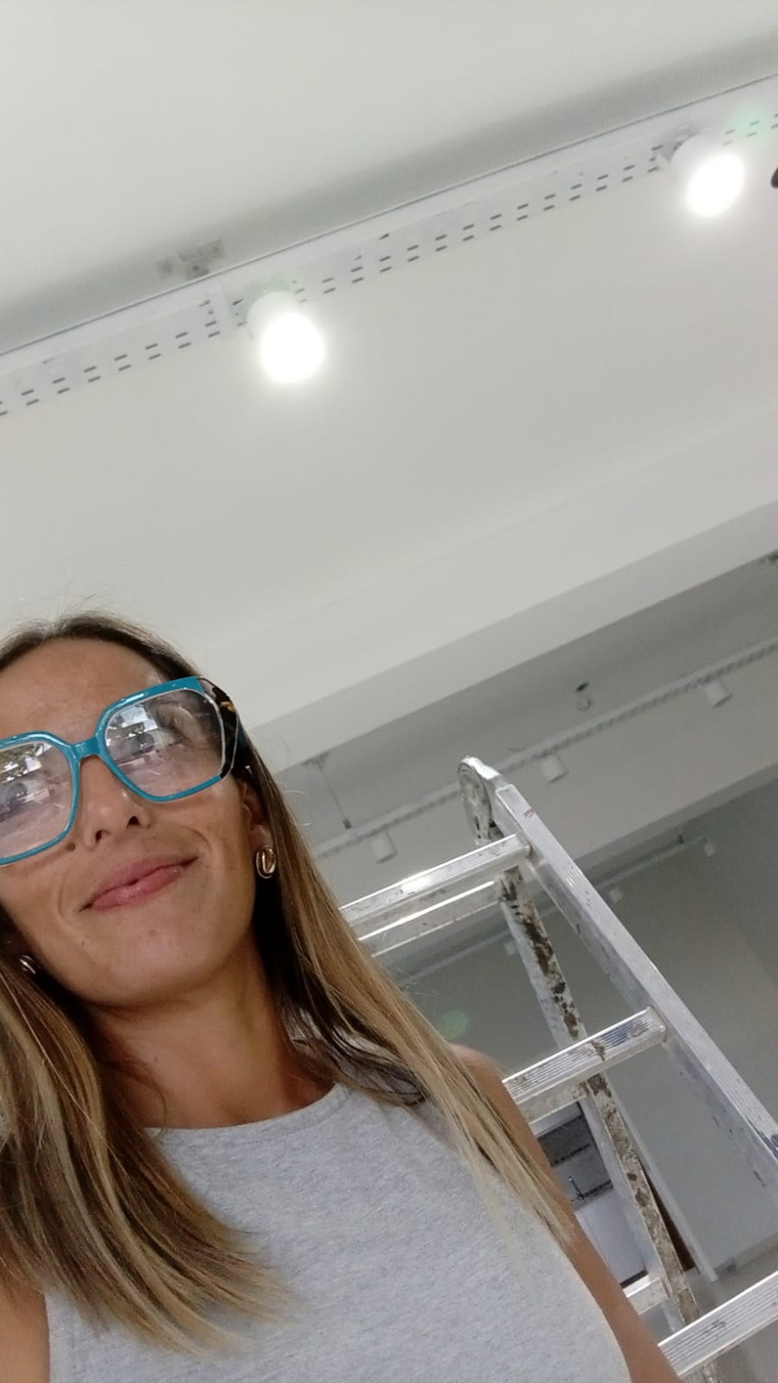 mujer con gafas toma selfie junto a escalera — proyecto MITRE SANITARIOS, por Yamil Cerna, en Tunuyán