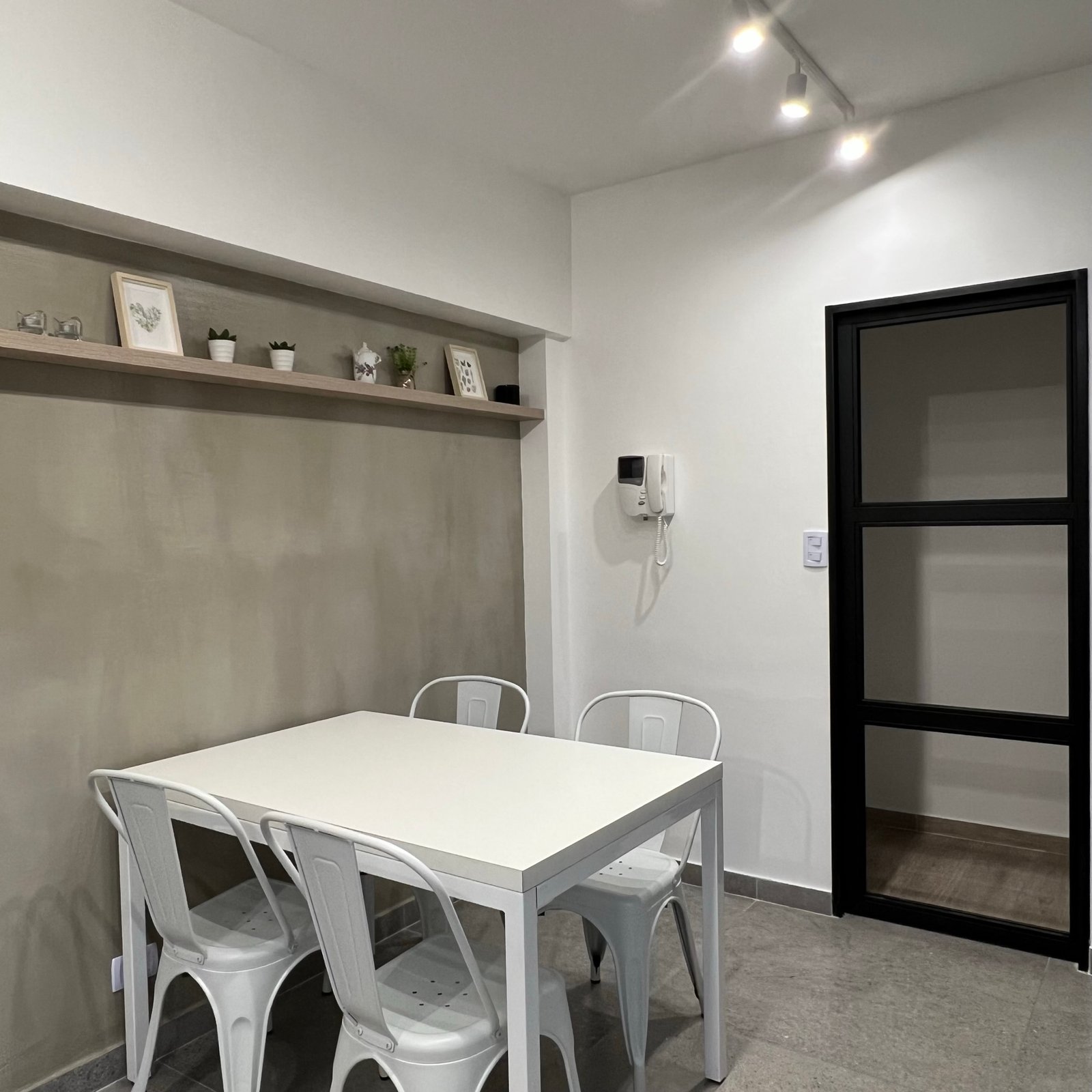 Sala de jantar minimalista com parede de concreto e mesa branca — projeto Vera I, por MDBK Arquitectura, em Villa Crespo