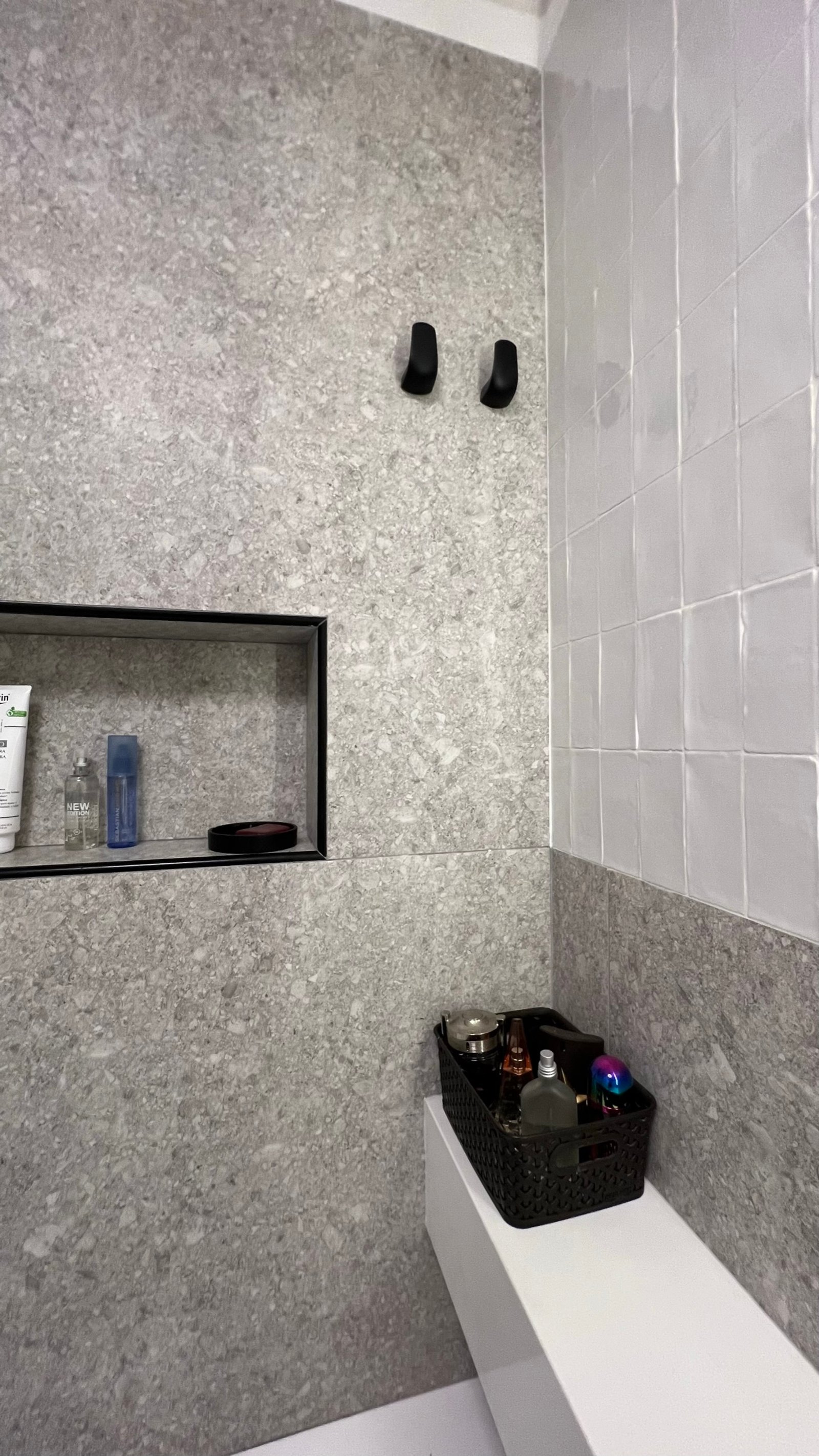 Baño moderno con paredes de piedra y cerámica, estantes empotrados y canasta organizadora — proyecto Cranwell, por MDBK Arquitectura, en Flores