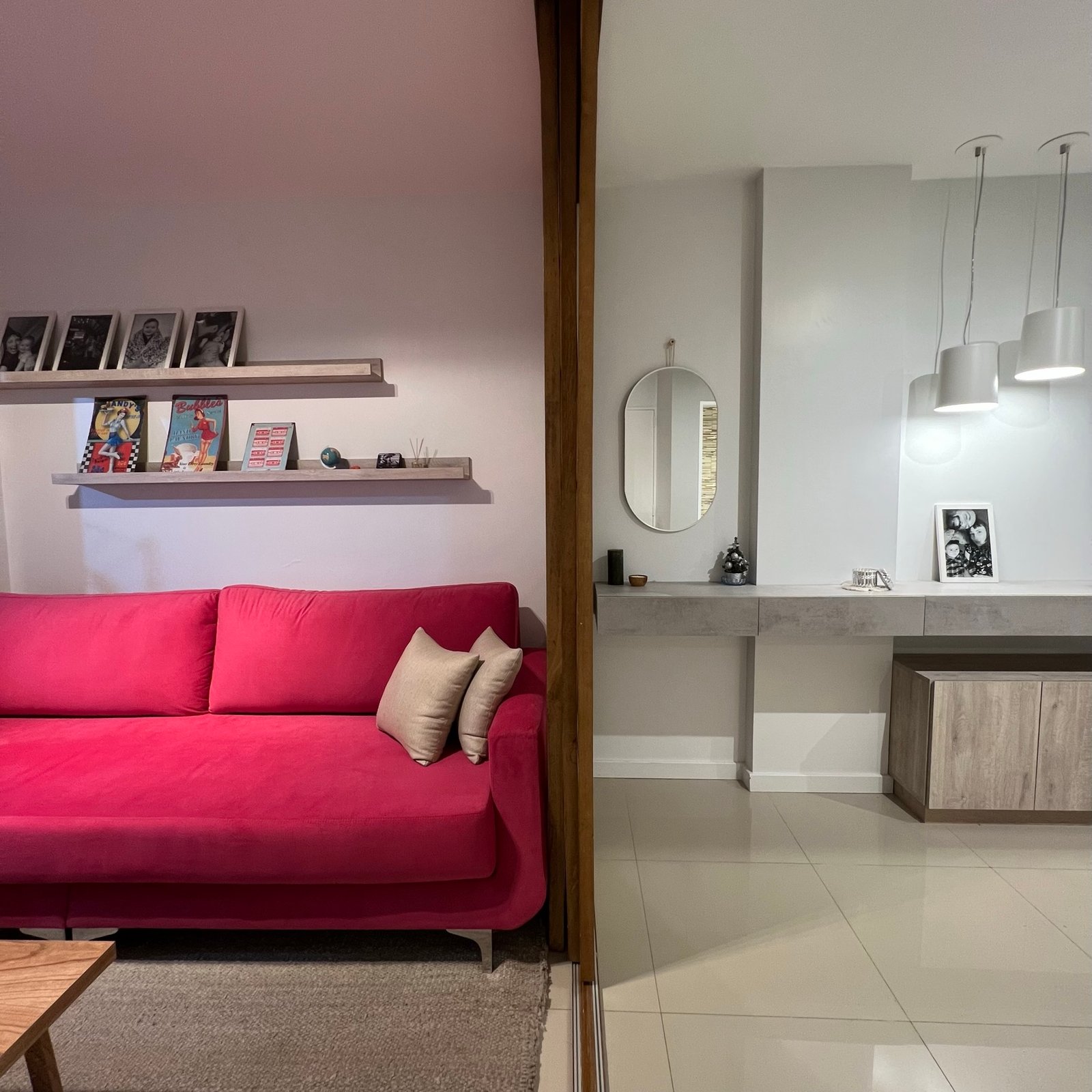 Sala moderna com sofá pink, prateleiras brancas e espelho redondo — projeto Epuyen II, por MDBK Arquitectura, em Caballito