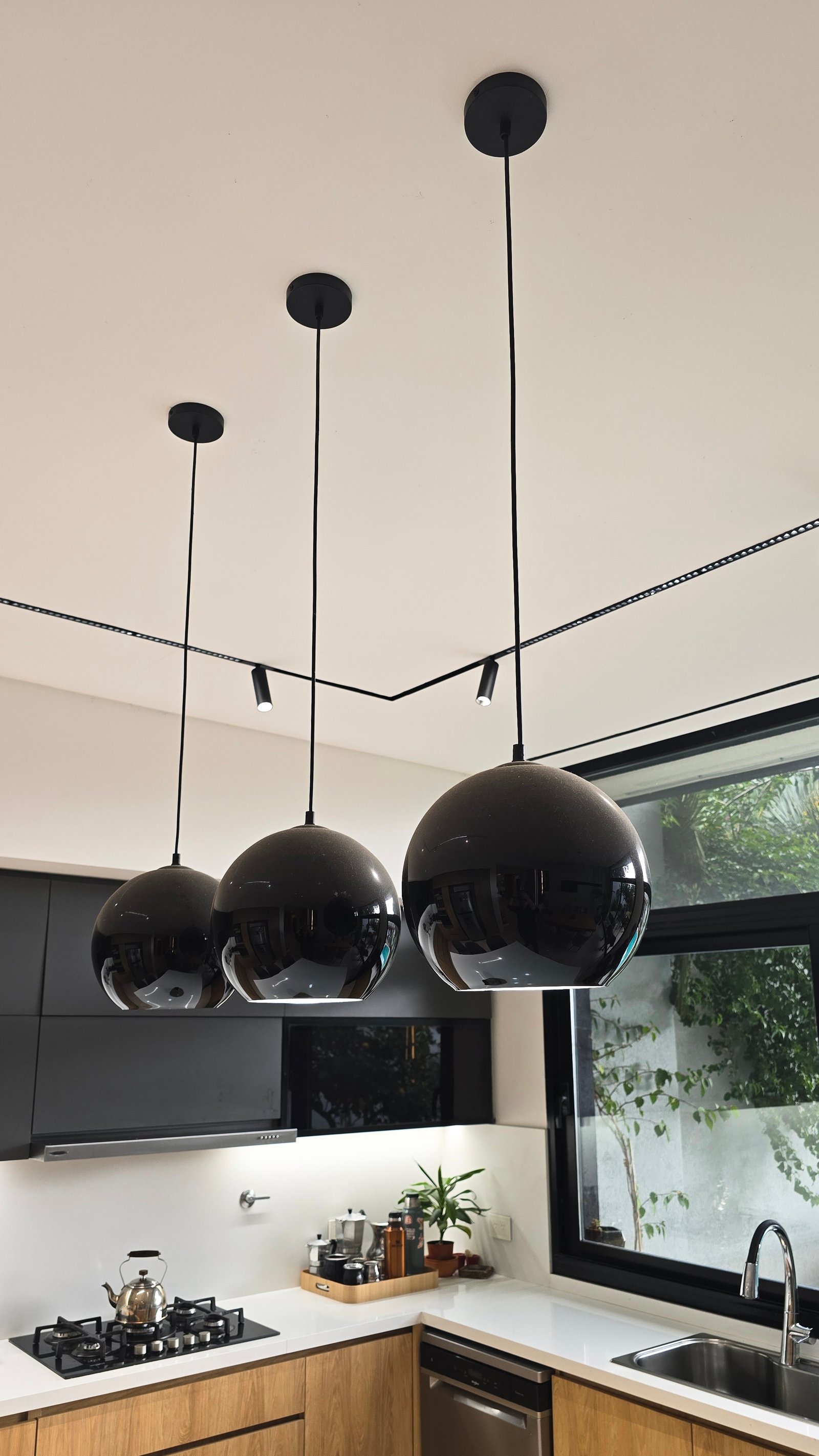 Cozinha moderna com pendentes pretos e armários de madeira — projeto Casa YyF, por Smr Arquitectura, em B1828 Banfield