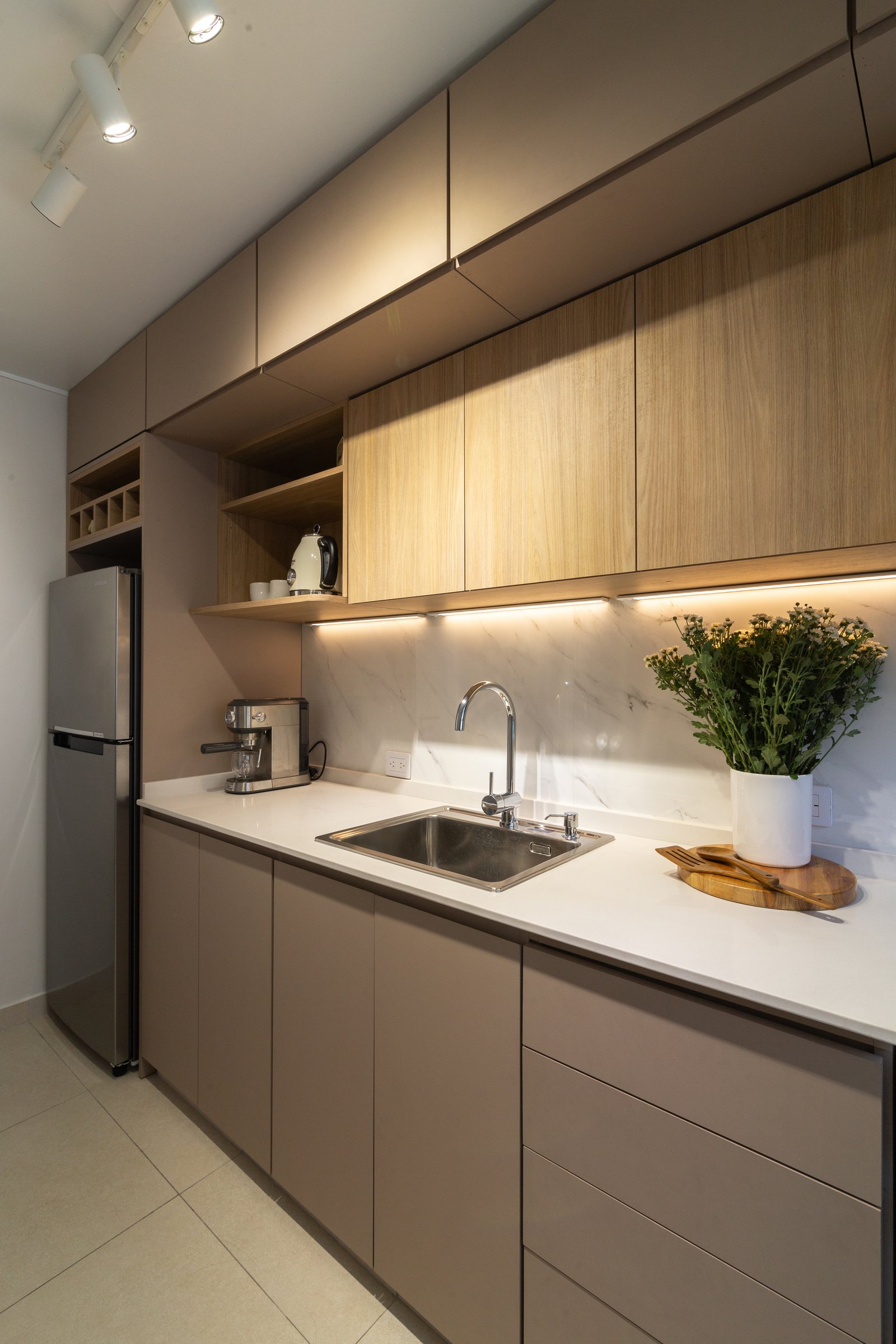Cocina moderna minimalista con muebles de madera natural y encimeras de piedra — proyecto Gascón, por Martina Kleinert, en Caballito
