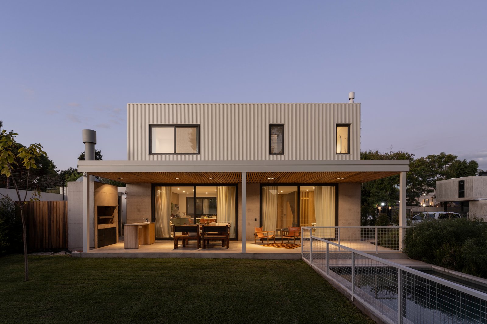 Casa moderna con amplios ventanales y patio — proyecto CASA CC, por Rastro Estudio, en San Isidro