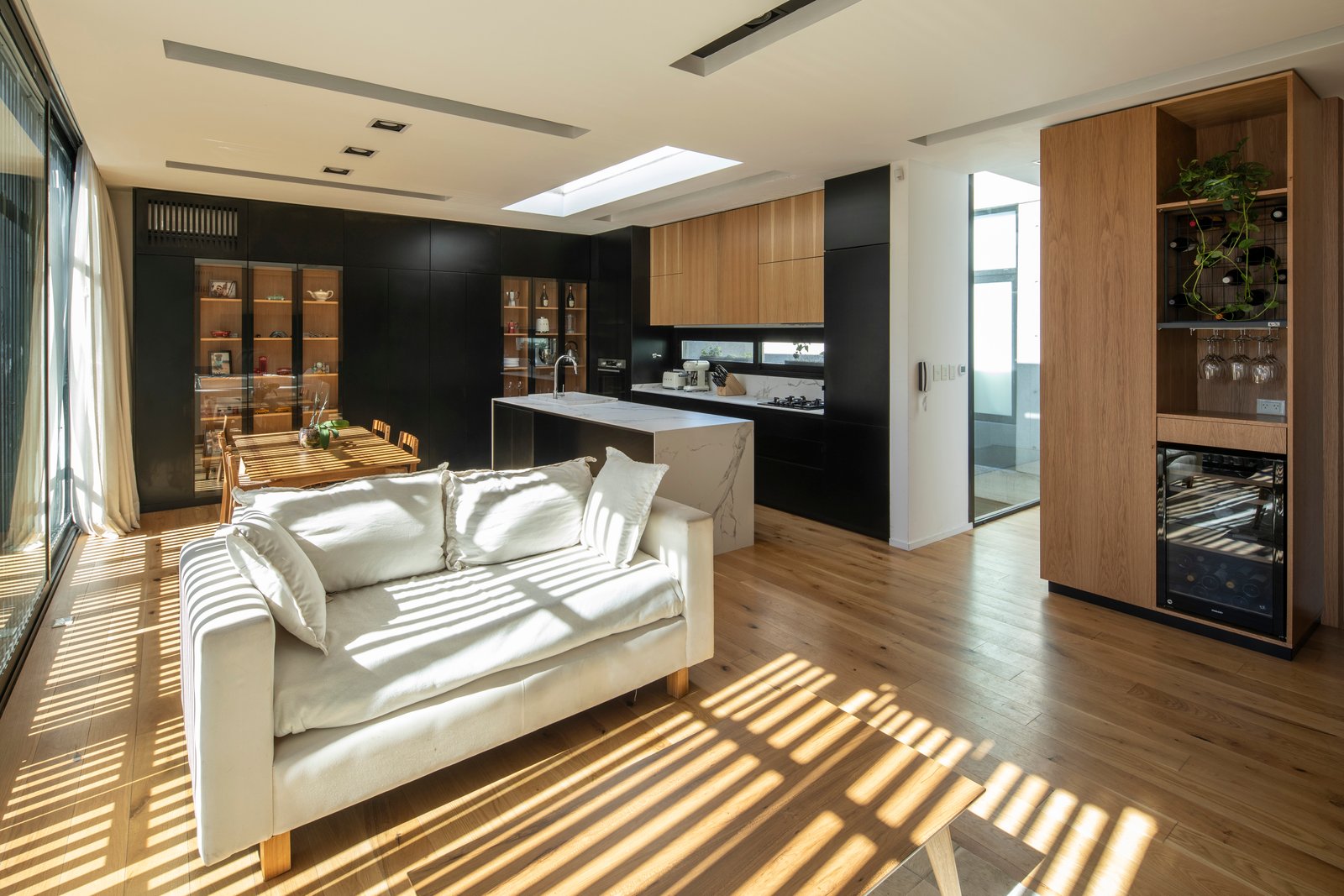 Sala de estar moderna de planta abierta con mucha luz natural — proyecto Casa MECHA, por Grupo CRBN, en B1712 Castelar