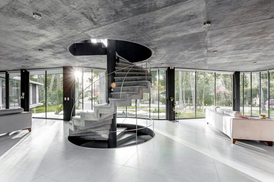 Amplio interior moderno con escalera caracol y hormigón expuesto — proyecto Casa Ameba, por MUCHTEK, en Cariló
