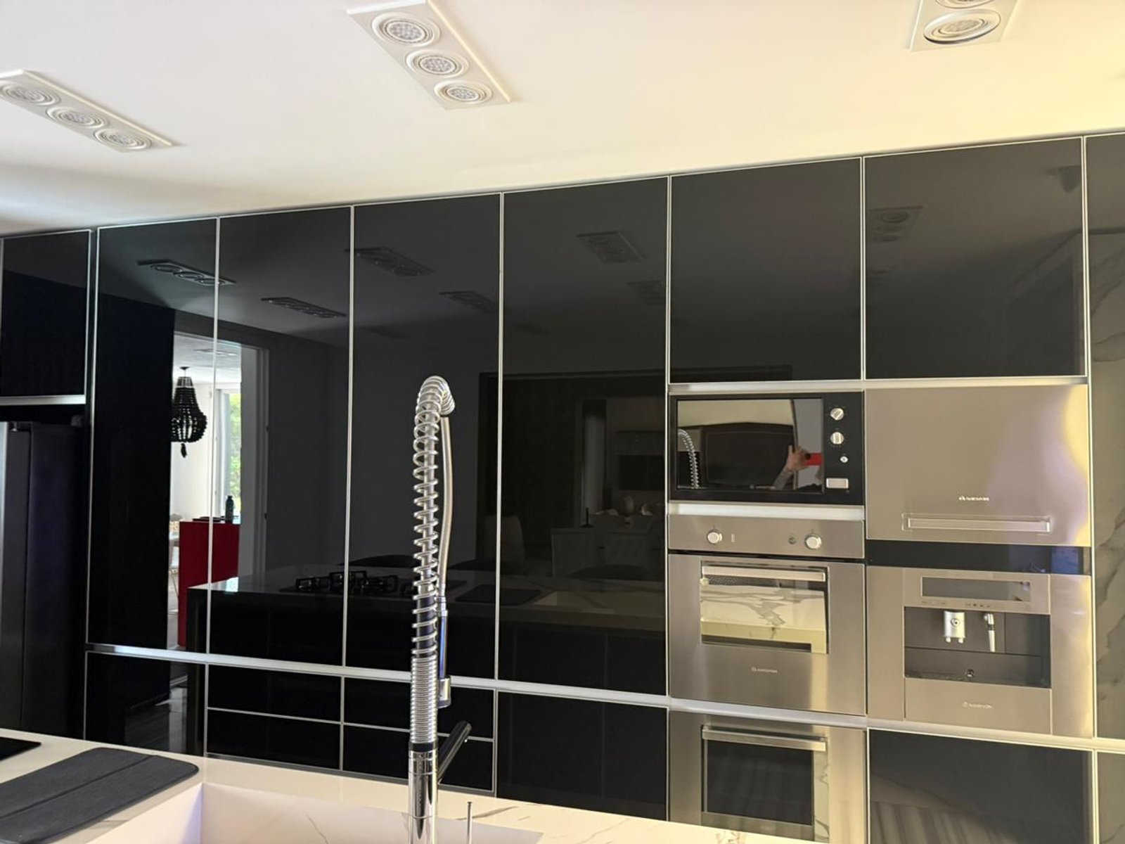 Cozinha moderna com armários pretos de vidro e eletrodomésticos embutidos — projeto Puertas alacena en cover negro, por Cristalcenter, em Pilar