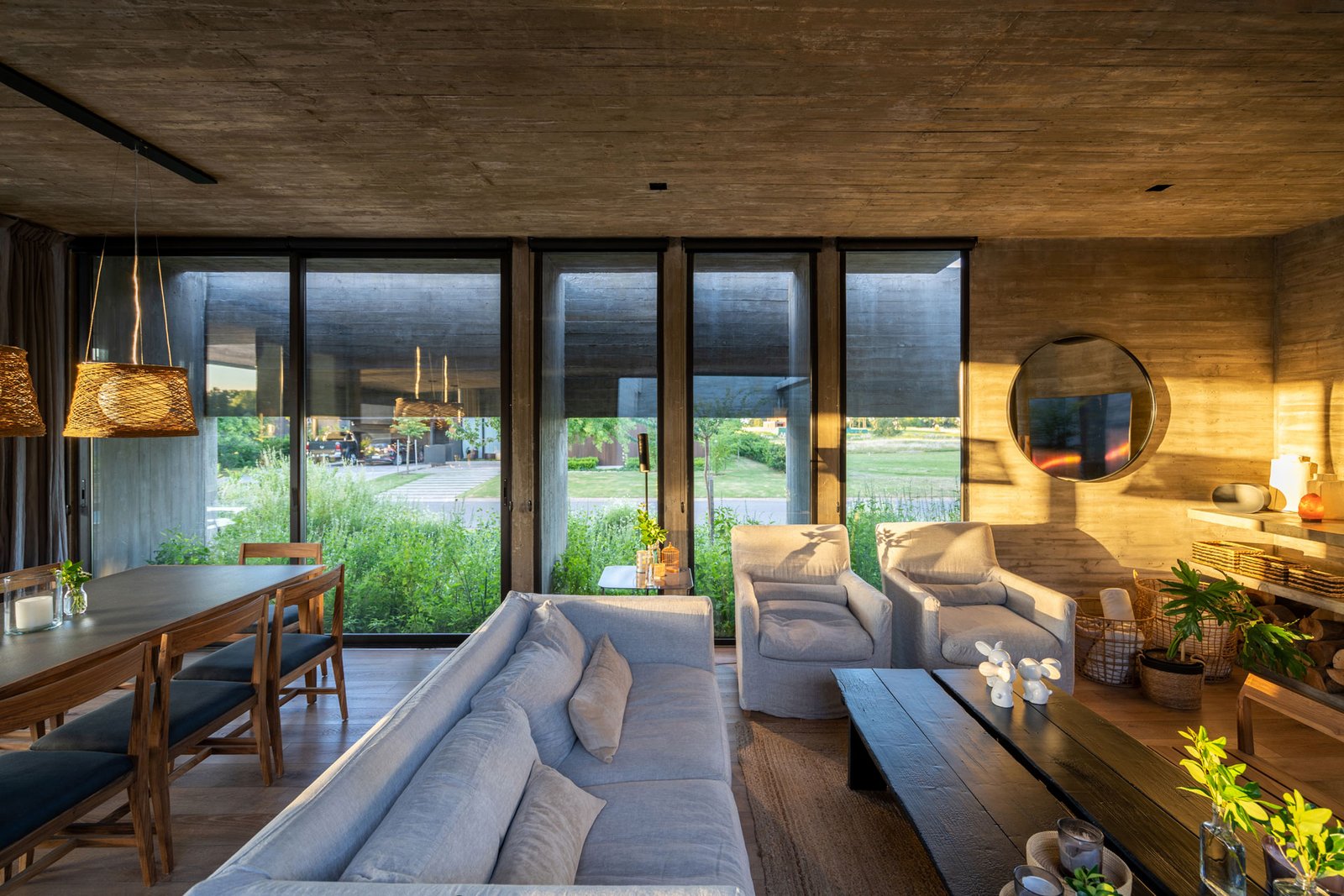 Living moderno de hormigón con mucha luz y vegetación exterior — proyecto Casa Tres Patios, por Besonías Almeida arquitectos, en Pilar