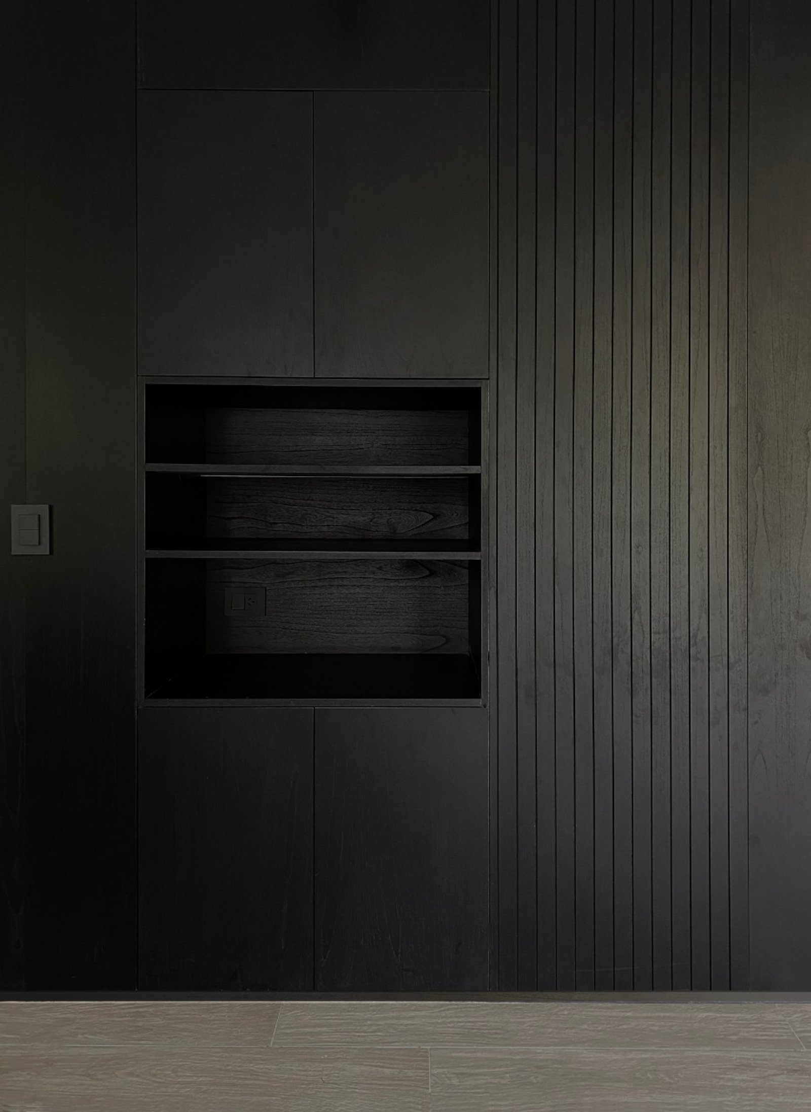 Sala moderna con pared de listones de madera oscura y almacenamiento empotrado — proyecto Pampa, por ABEJA CONCEPT, en Belgrano