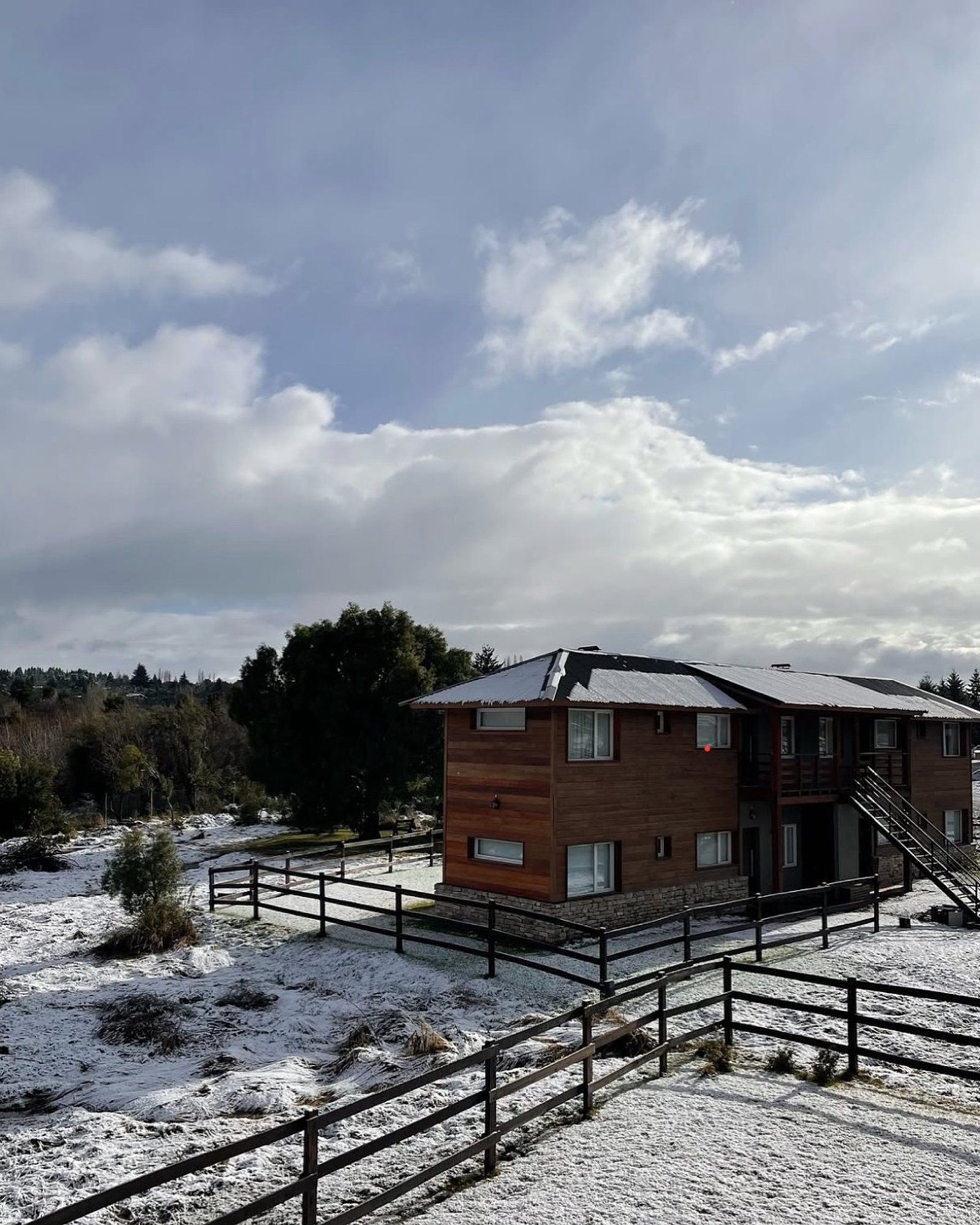 Casa de madeira moderna com neve e cercas pretas — projeto La Pampita, por Arquitecta Grace Overgaard, em Lago Gutiérrez
