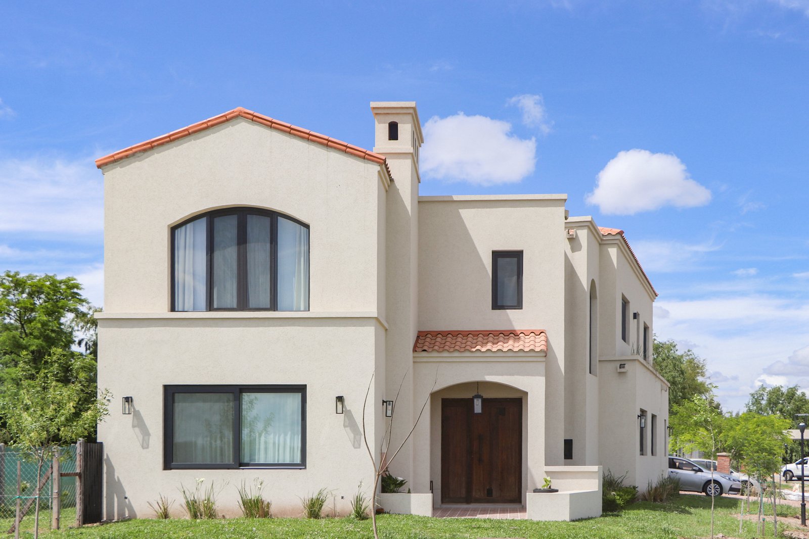 Fachada de casa moderna estilo mediterrâneo com reboco e telhado de terracota — projeto Casa San Fermin 200, por R+B arquitectos, em Pasteur 662