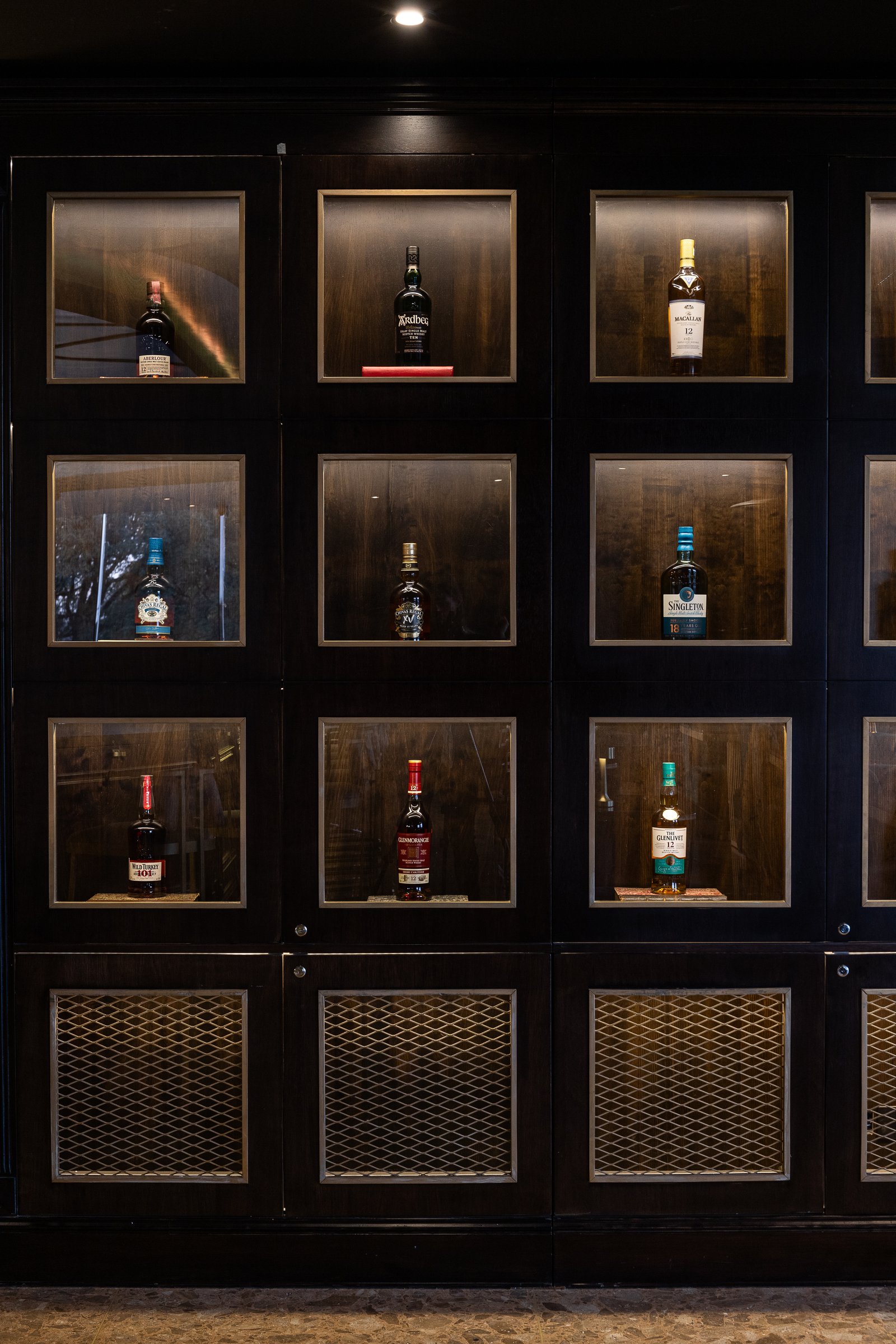 vitrine de bebidas de madeira escura com iluminação indireta — projeto PRESIDENTE BAR HIPODROMO, por AB ARQUITECTURA, em San Isidro