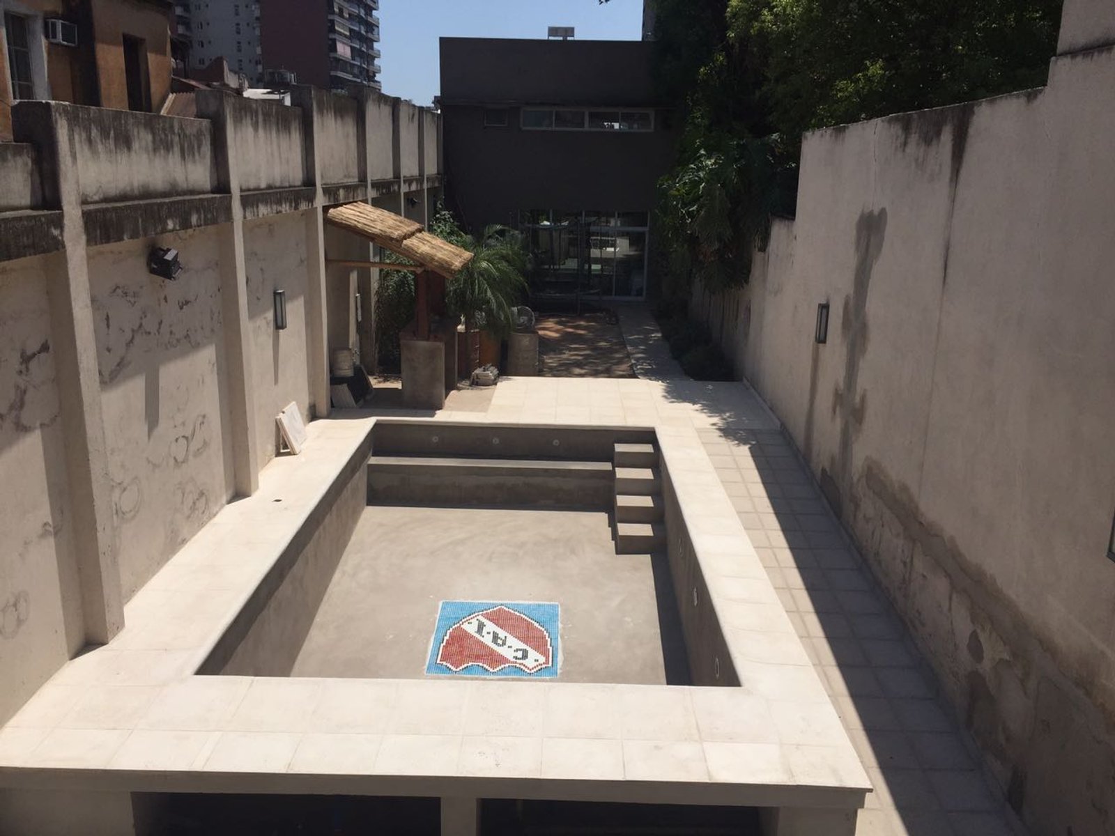 Pátio com piscina inacabada em construção — projeto PISCINA ORTIZ MAYOR, por HORACIO MEJAIL, em Héroes de Malvinas
