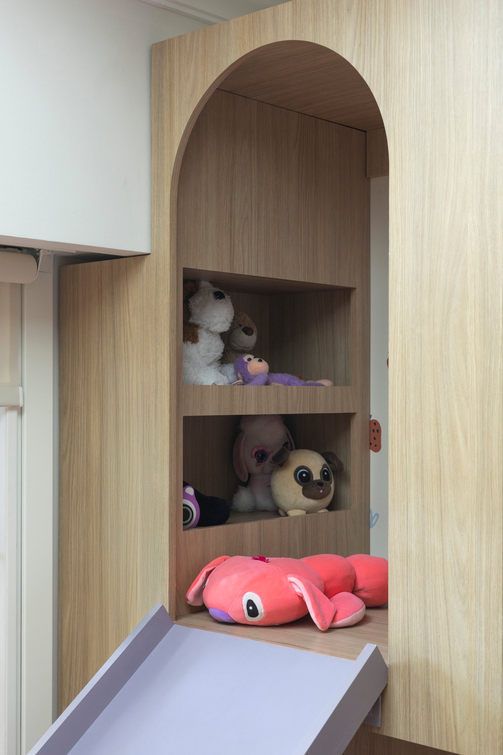 Estantería arqueada de madera con peluches y tobogán incorporado — proyecto MONASTERIO, por La Nave Arq., en Vicente López