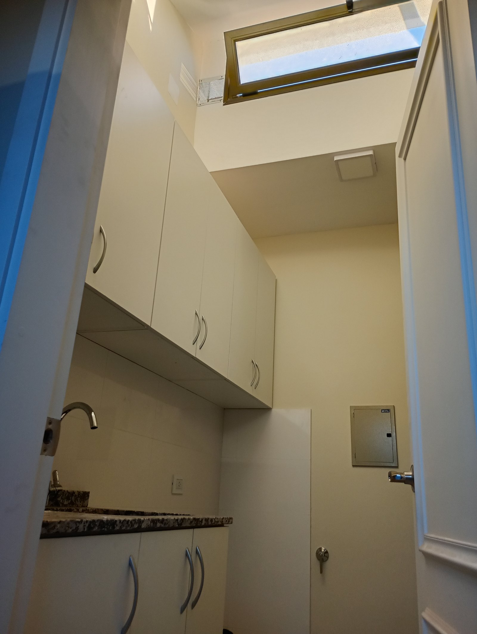 Lavadero moderno con techos altos y ventana tipo dormer — proyecto Proyecto R-M, por TERROC, en Maipú