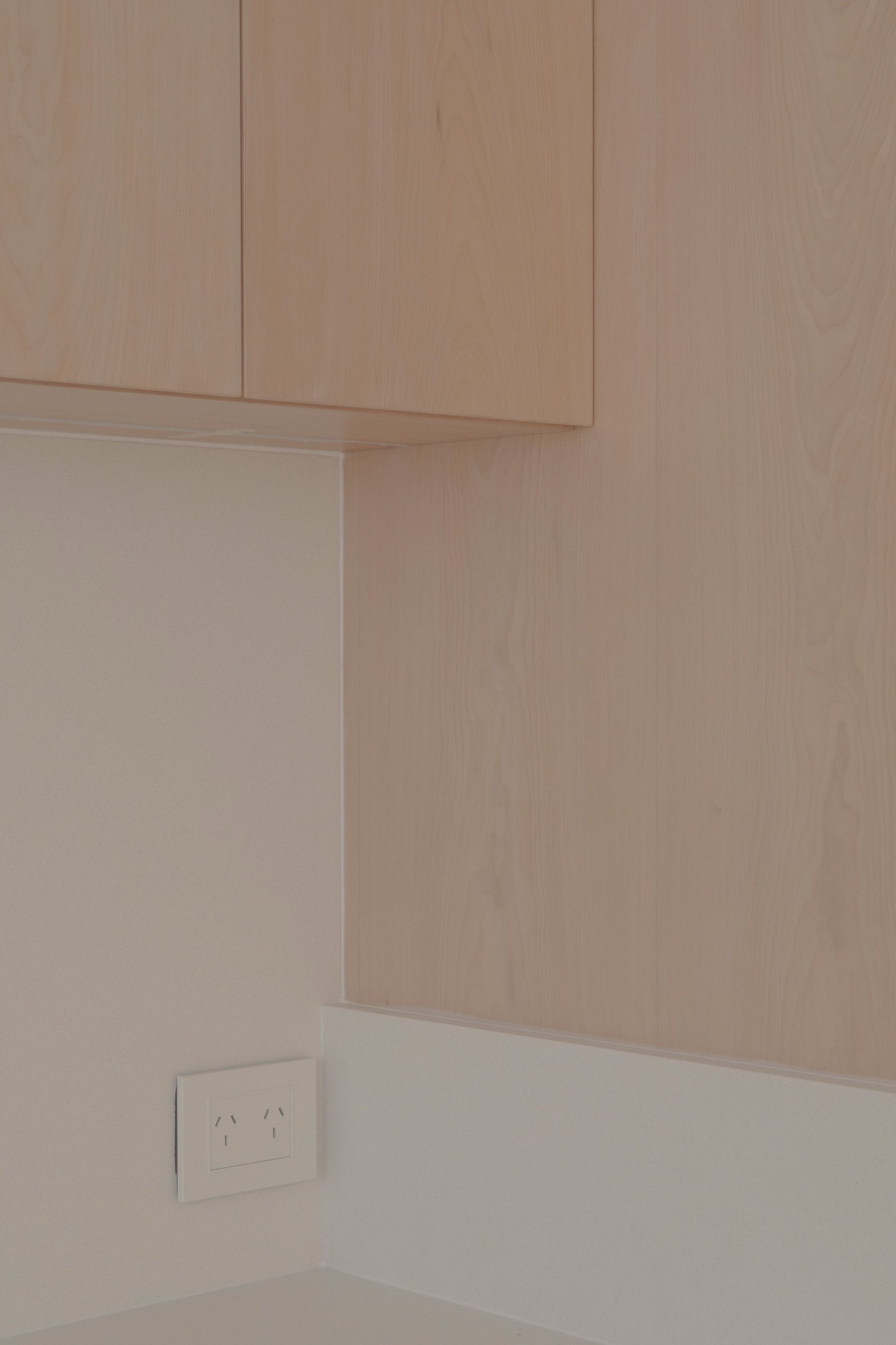 muebles de cocina y pared de madera clara, toma de corriente blanca — proyecto Reforma O'Higgins, por Estudio YME, en Belgrano
