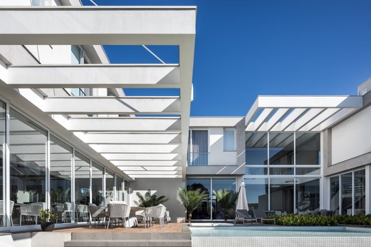 Fachada moderna con piscina y pérgola — proyecto CASA AG, por ARQUITETARE POR ELAINE ZANON & CLAUDIA MACHADO, en Curitiba