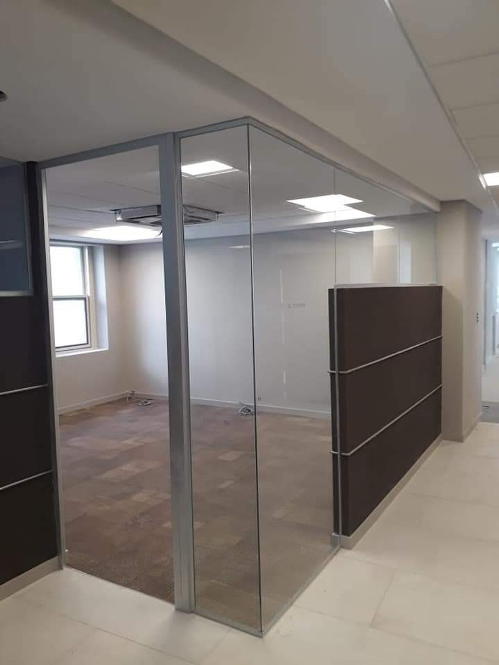 Oficina moderna con mamparas de vidrio y detalles en madera oscura — proyecto Banco Galicia divisores, por Cristalcenter, en Maipú