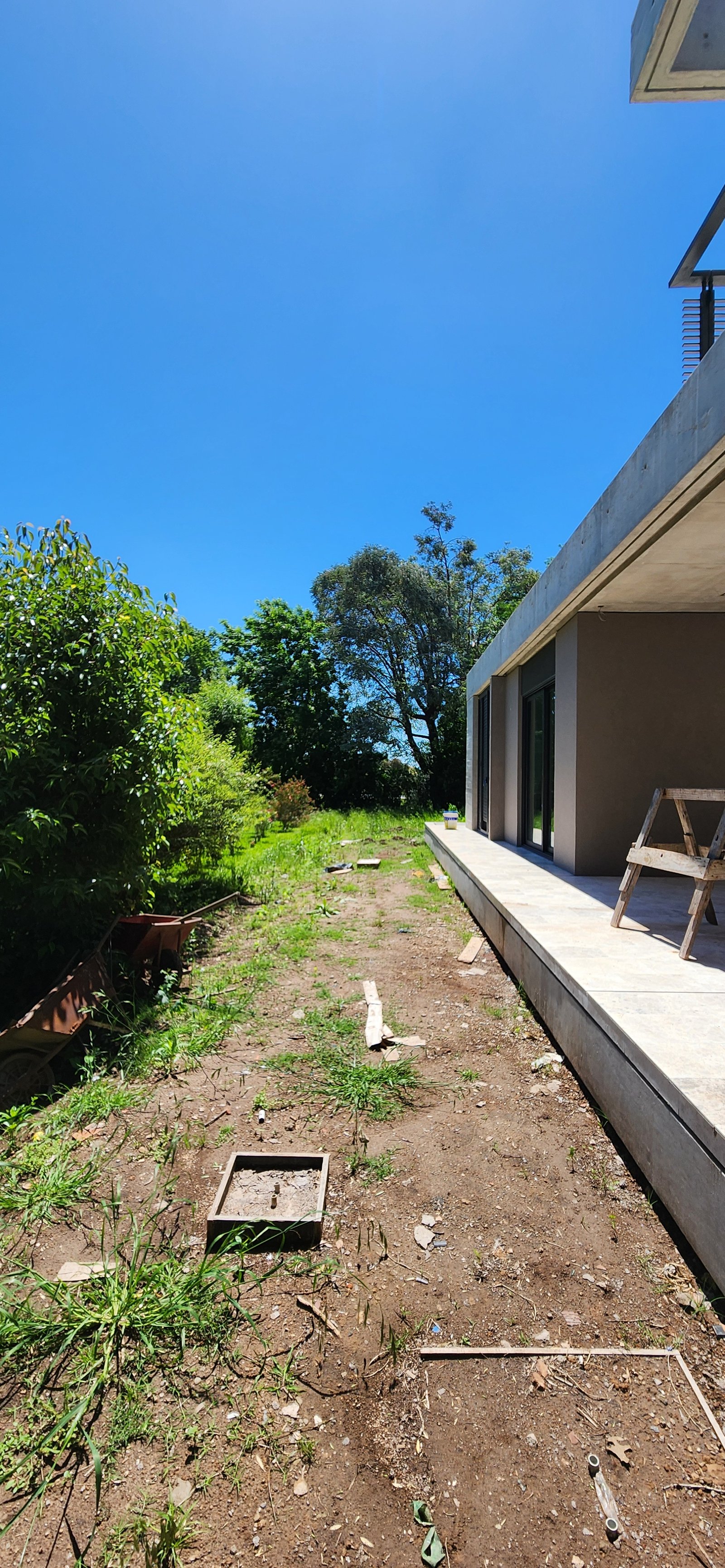 casa moderna em construção com jardim e árvores — projeto Casa CAD, por Estudio Rifahi, em Moreno