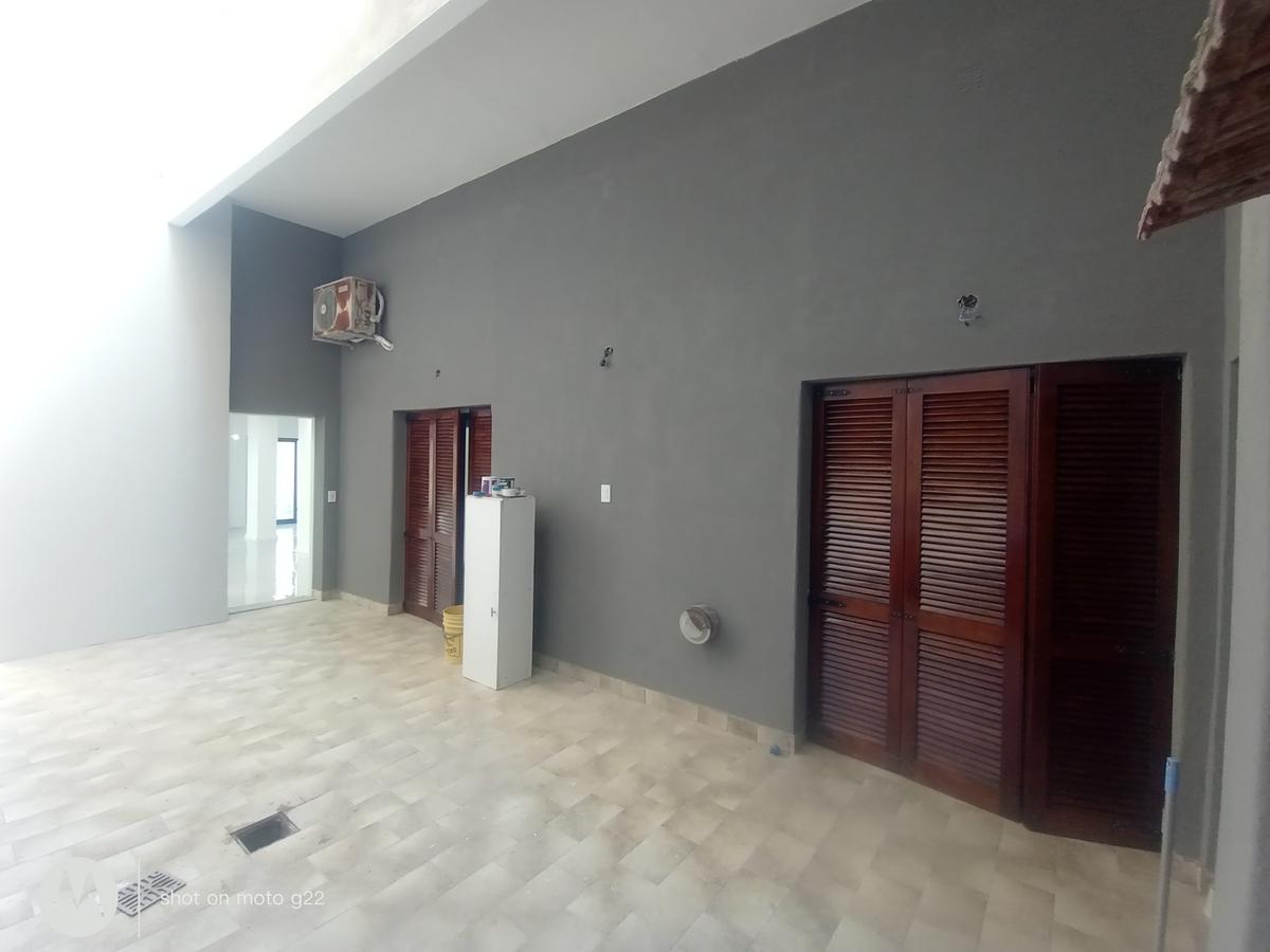 fachada moderna con puertas de madera oscura y patio — proyecto Trabajos realizados , por Ayc Pinturas y Revestimientos, en Canning