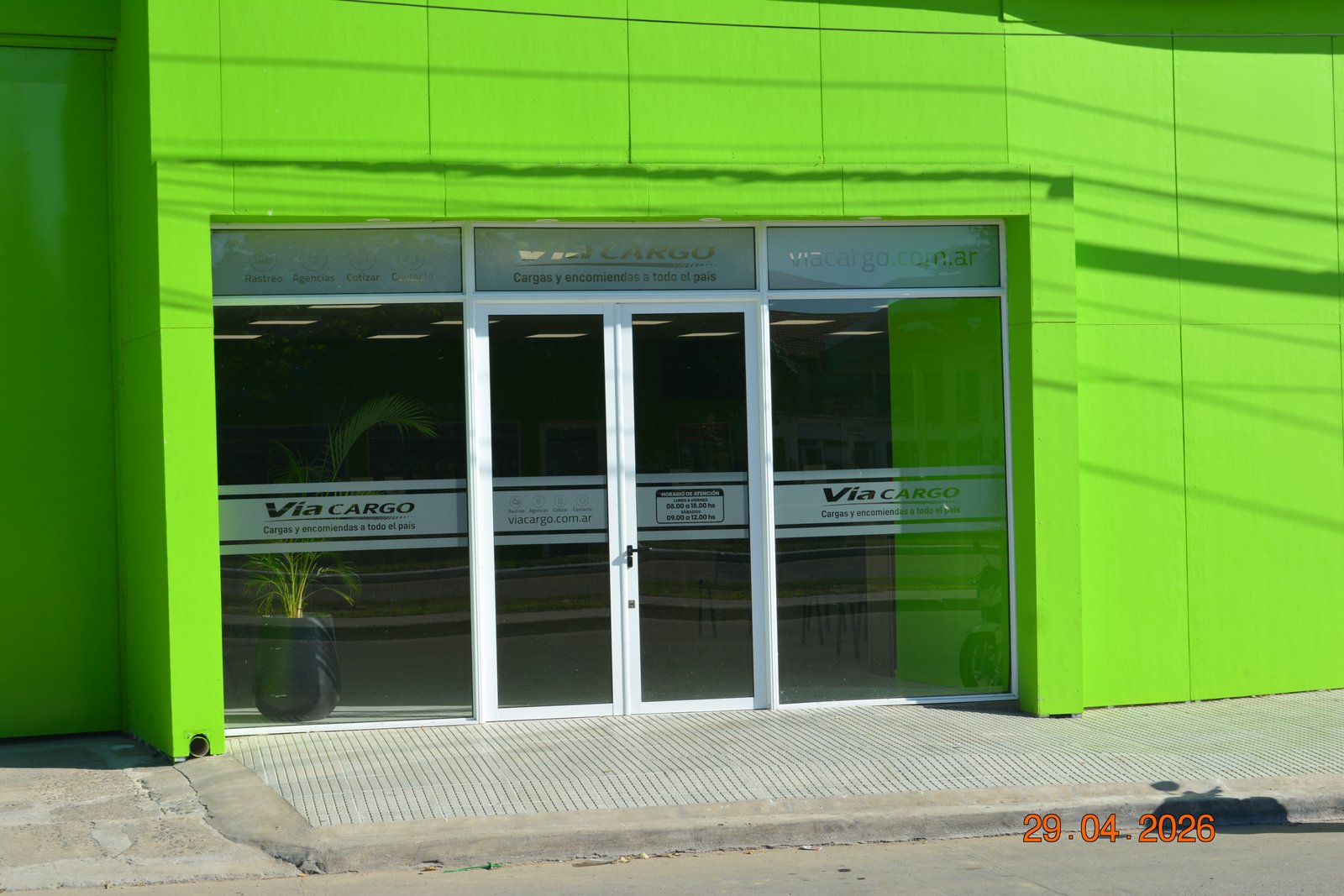 fachada verde brillante con entrada de vidrio — proyecto Sucursal Via Cargo, filial Corrientes, Empresa de distribución y logística., por Arquitecto Gustavo Maidana, en Corrientes
