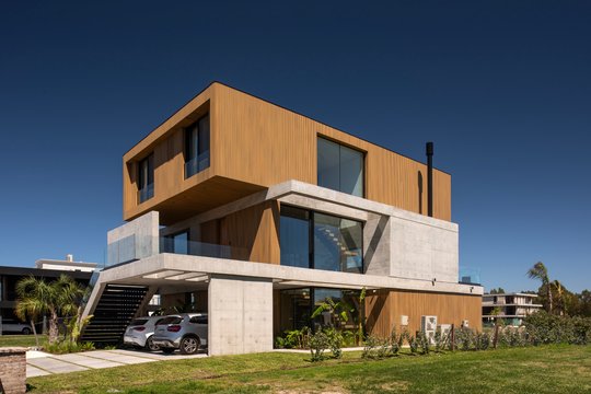fachada moderna de casa con volúmenes geométricos — proyecto Obra Casa Yacht, por lifecycle, en Nordelta