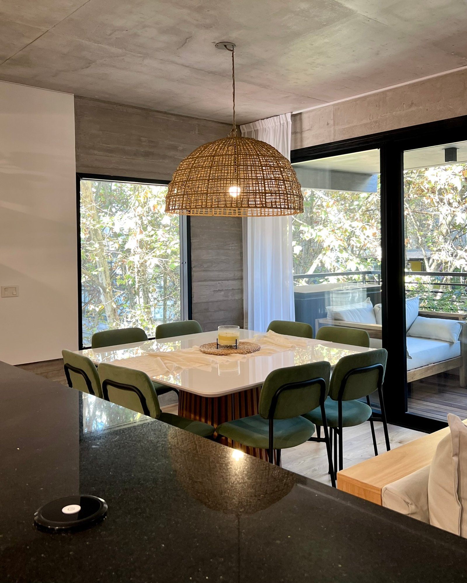 Comedor moderno con mesa de mármol, sillas verdes y lámpara de ratán — proyecto Guatemala, por MDBK Arquitectura, en Palermo
