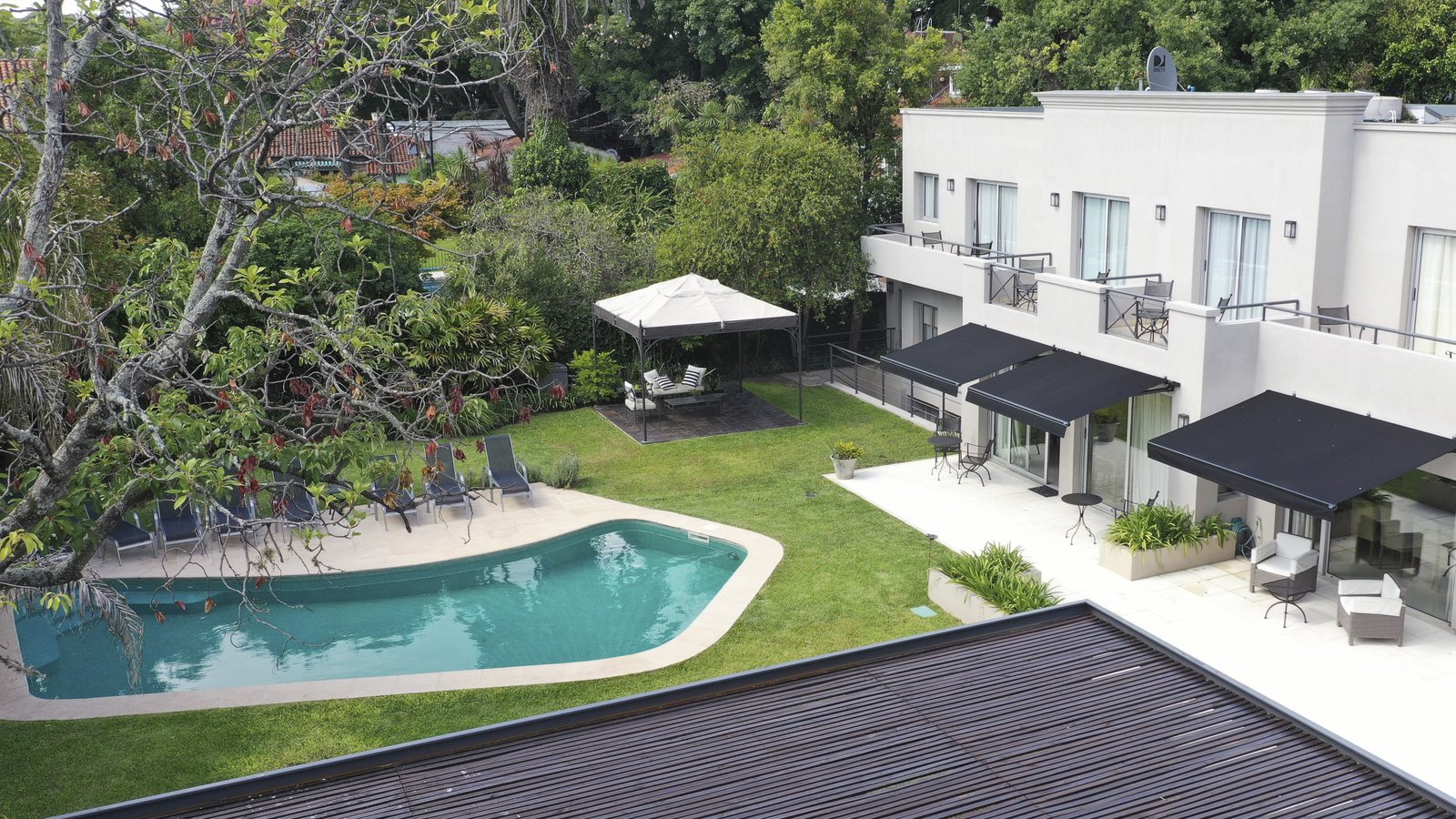 Casa moderna con piscina y jardín exuberante — proyecto Villa Isidro Hotel Boutique & Spa, por Hermann Arquitectos, en San Isidro