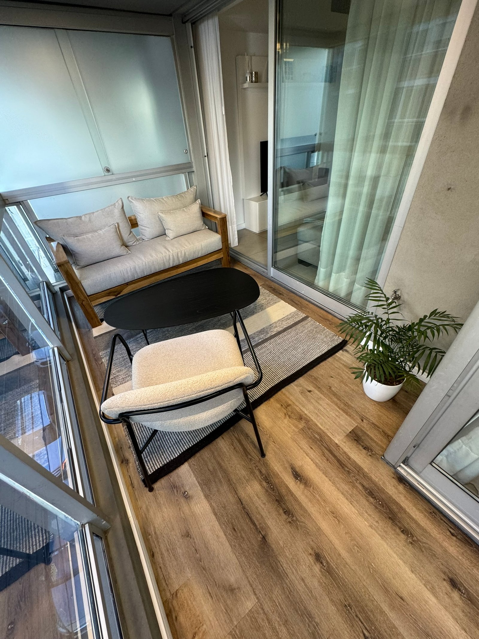 Balcón moderno con sofá, sillón y planta — proyecto Salguero I, por MDBK Arquitectura, en Palermo