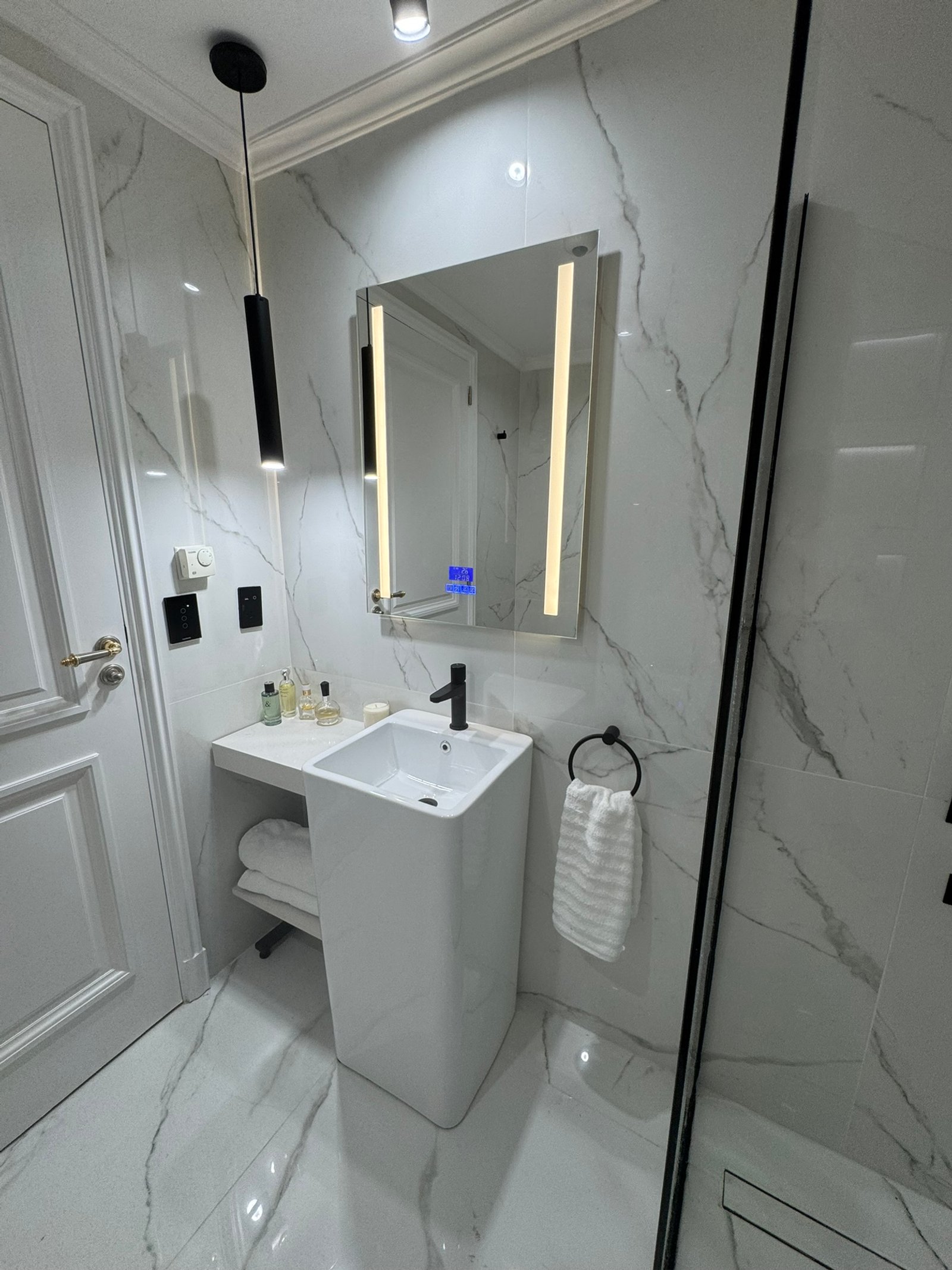 baño moderno con espejo iluminado y bacha pedestal — proyecto Chateau, por MDBK Arquitectura, en Puerto Madero