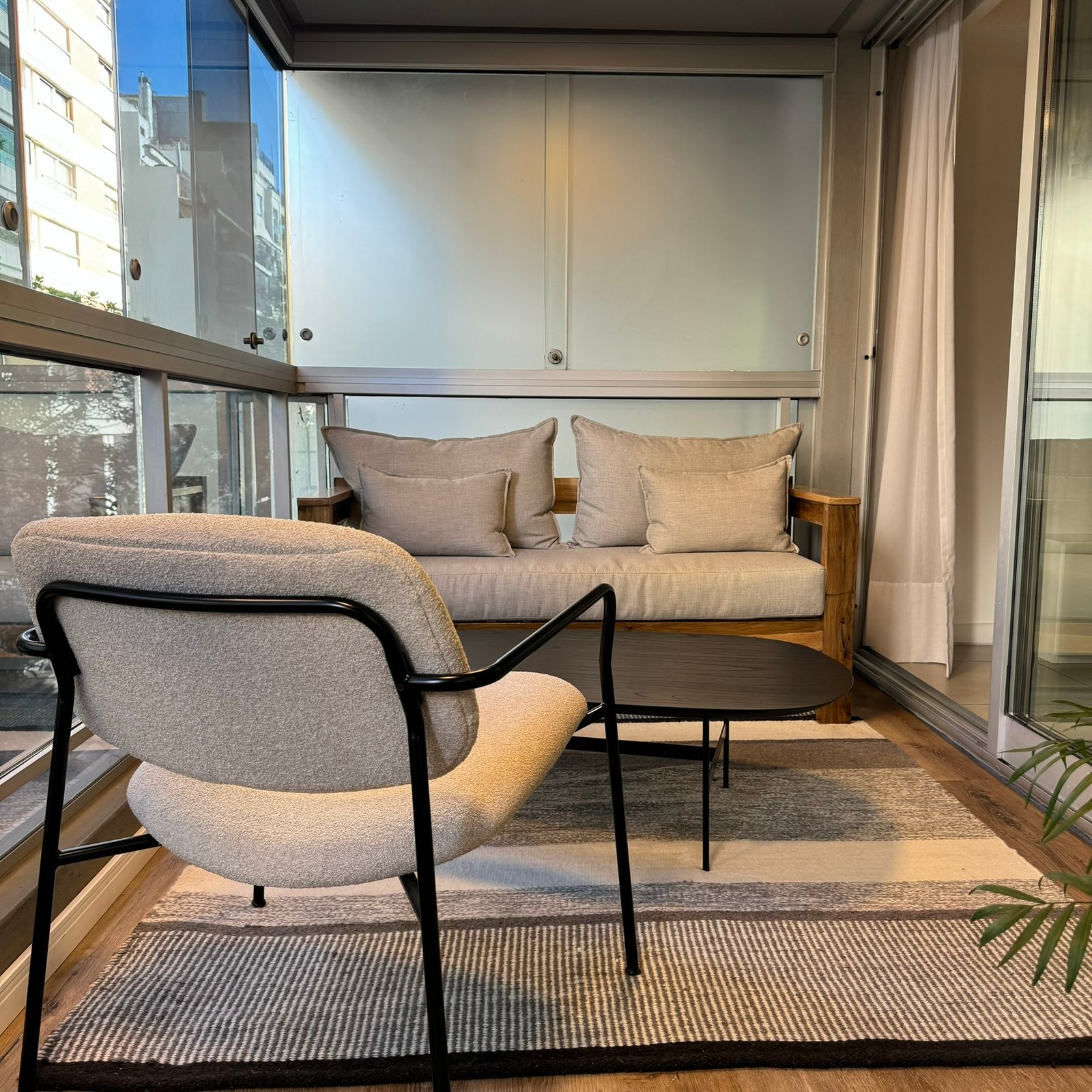Varanda moderna envidraçada com poltronas e vista urbana — projeto Salguero I, por MDBK Arquitectura, em Palermo