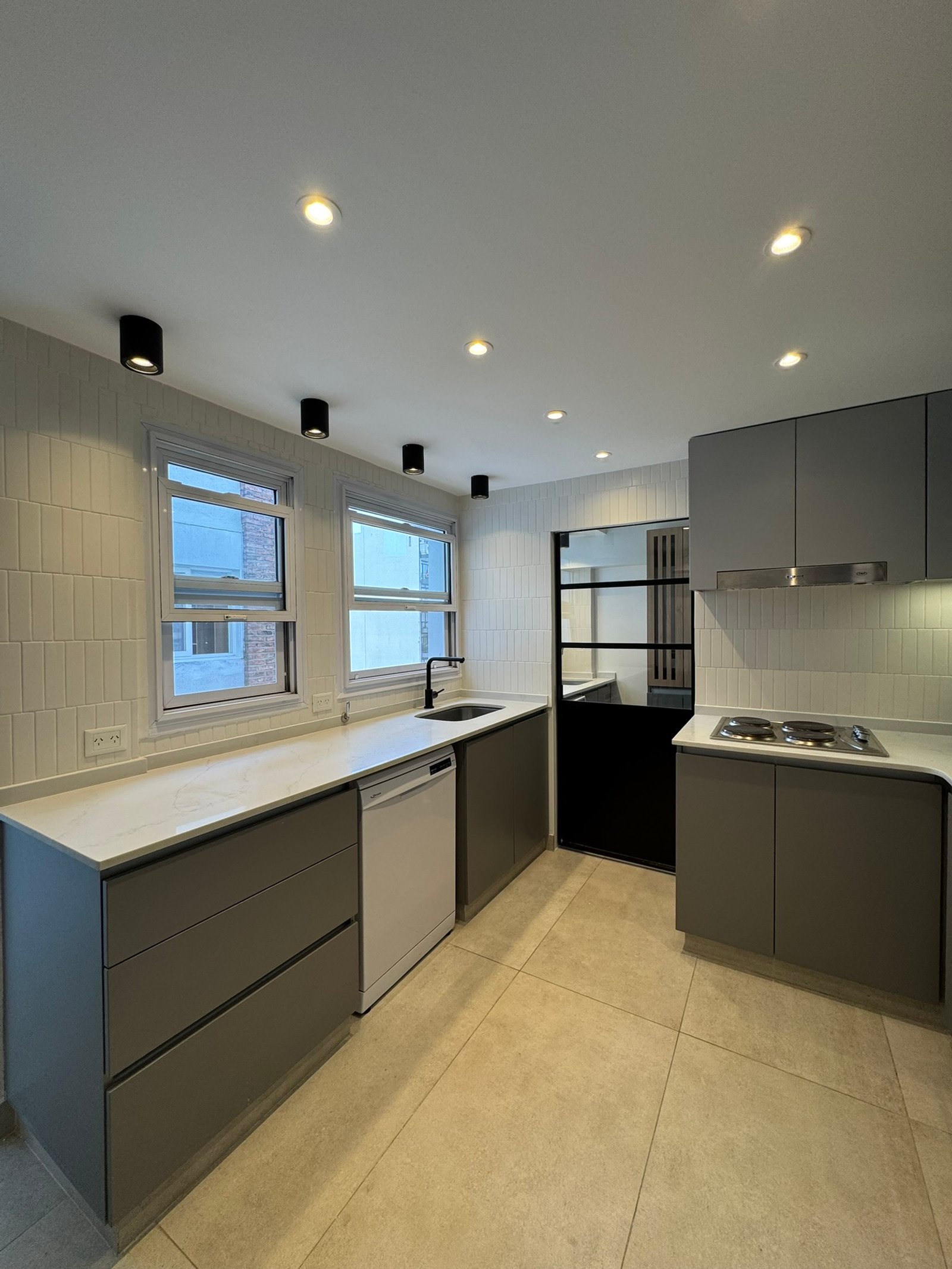 Cocina moderna con gabinetes grises minimalistas y encimera de mármol — proyecto Apolinario, por MDBK Arquitectura, en Villa Crespo
