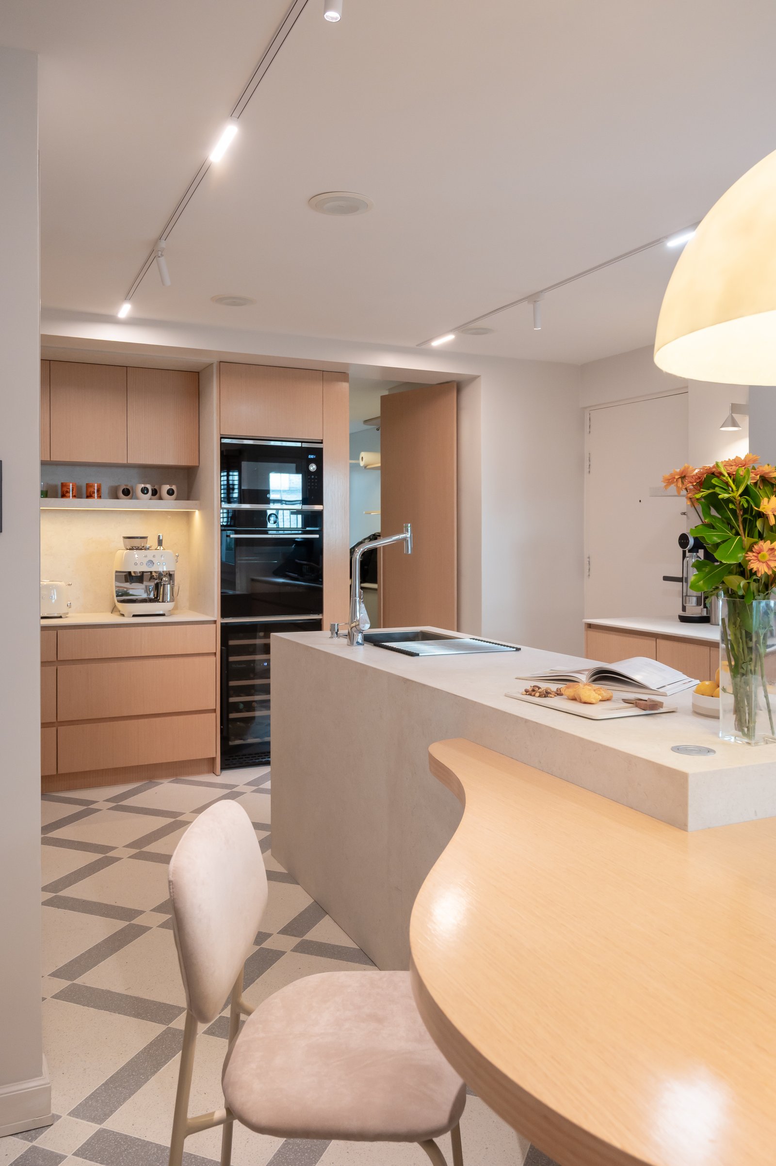 Cocina moderna escandinava con isla curva, gabinetes de madera y suelo geométrico — proyecto ALVEAR TYM, por AB ARQUITECTURA, en Recoleta