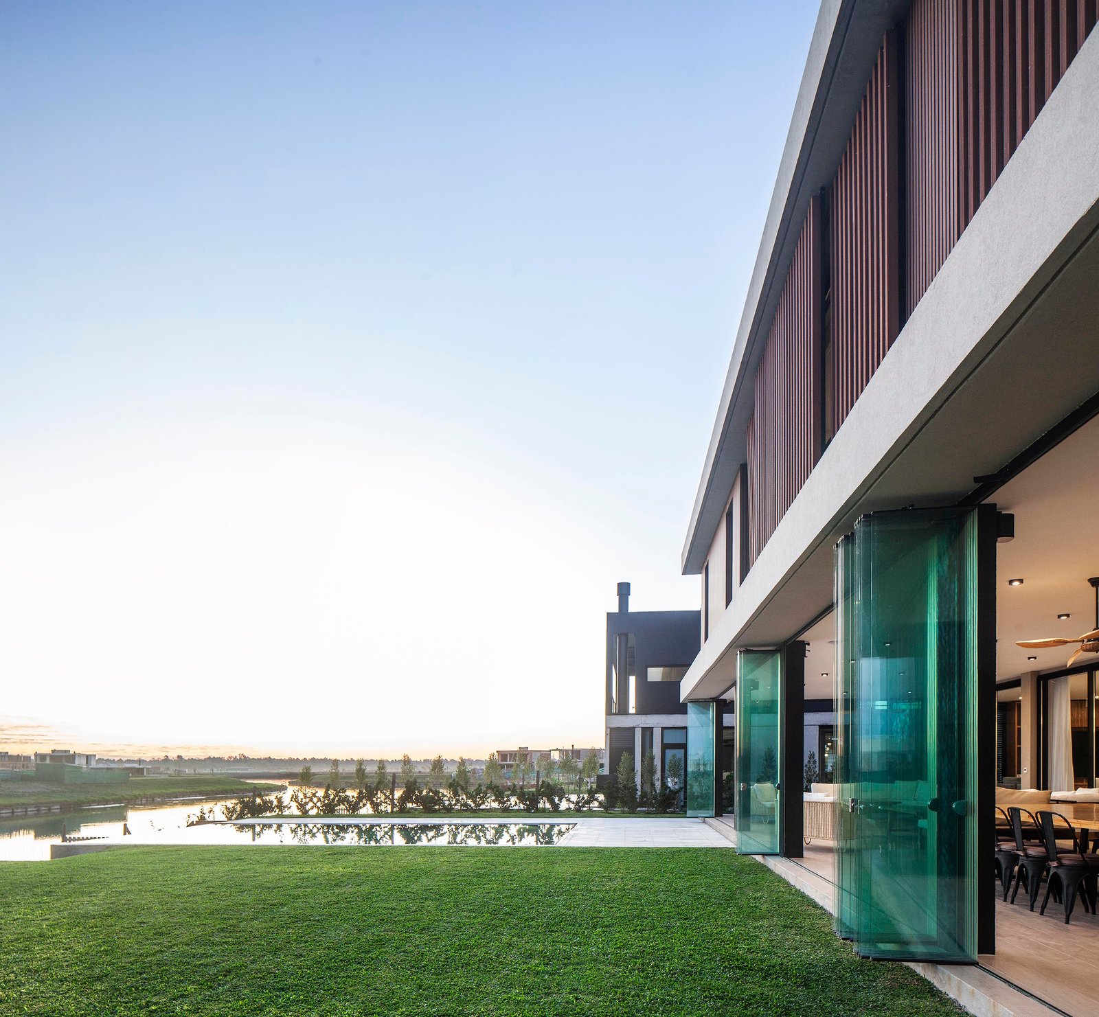 Fachada moderna litoral com janelas do chão ao teto — projeto CASA C313, por A'PRIMA - Arquitectura Sustentable, em Provincia de Buenos Aires