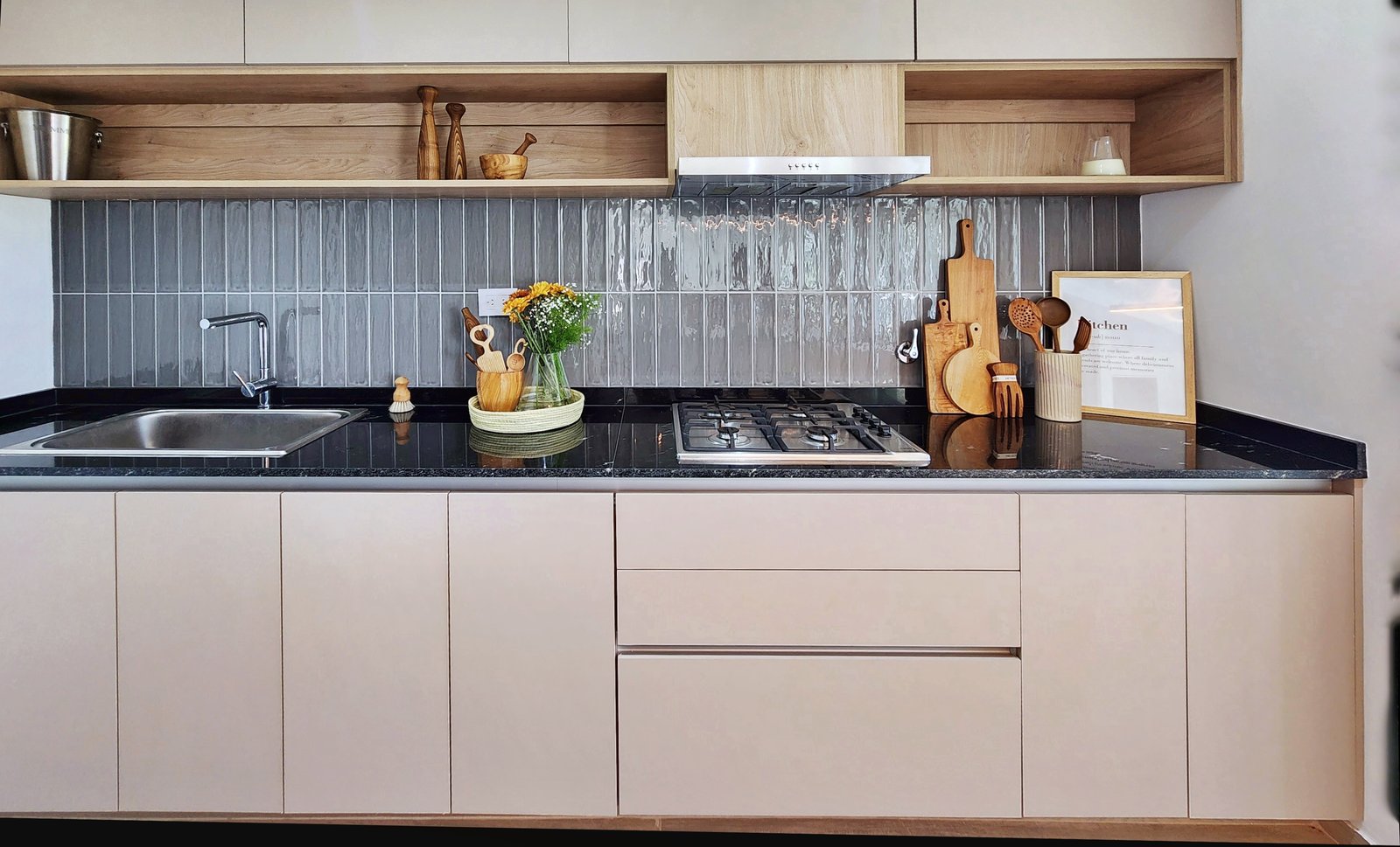 Cocina moderna con gabinetes beige, mesada negra y detalles en madera — proyecto San Simon II, por Estudio Stepa, en Canning
