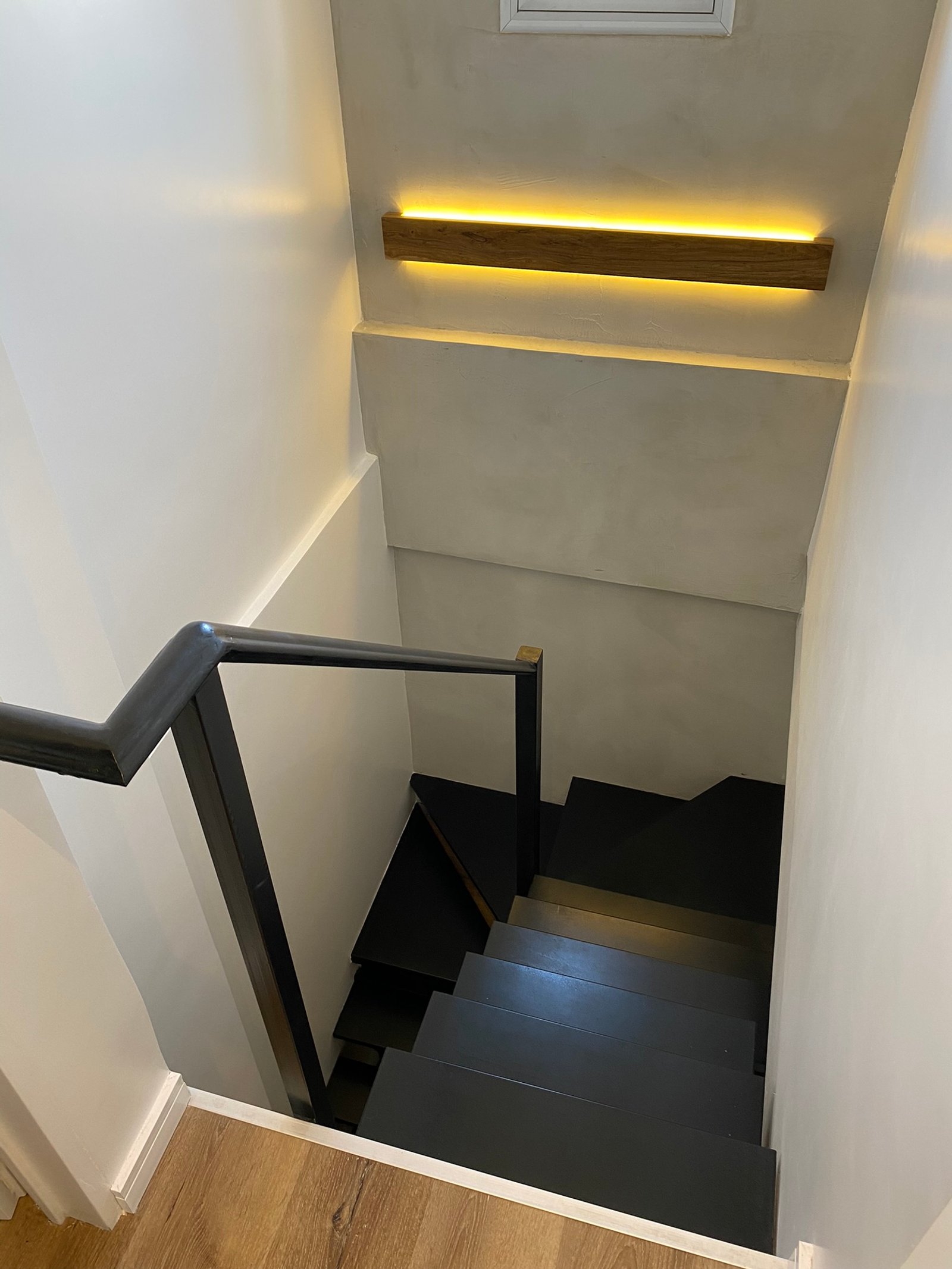 Escada flutuante moderna com iluminação indireta quente — projeto Burela, por MDBK Arquitectura, em Villa Urquiza