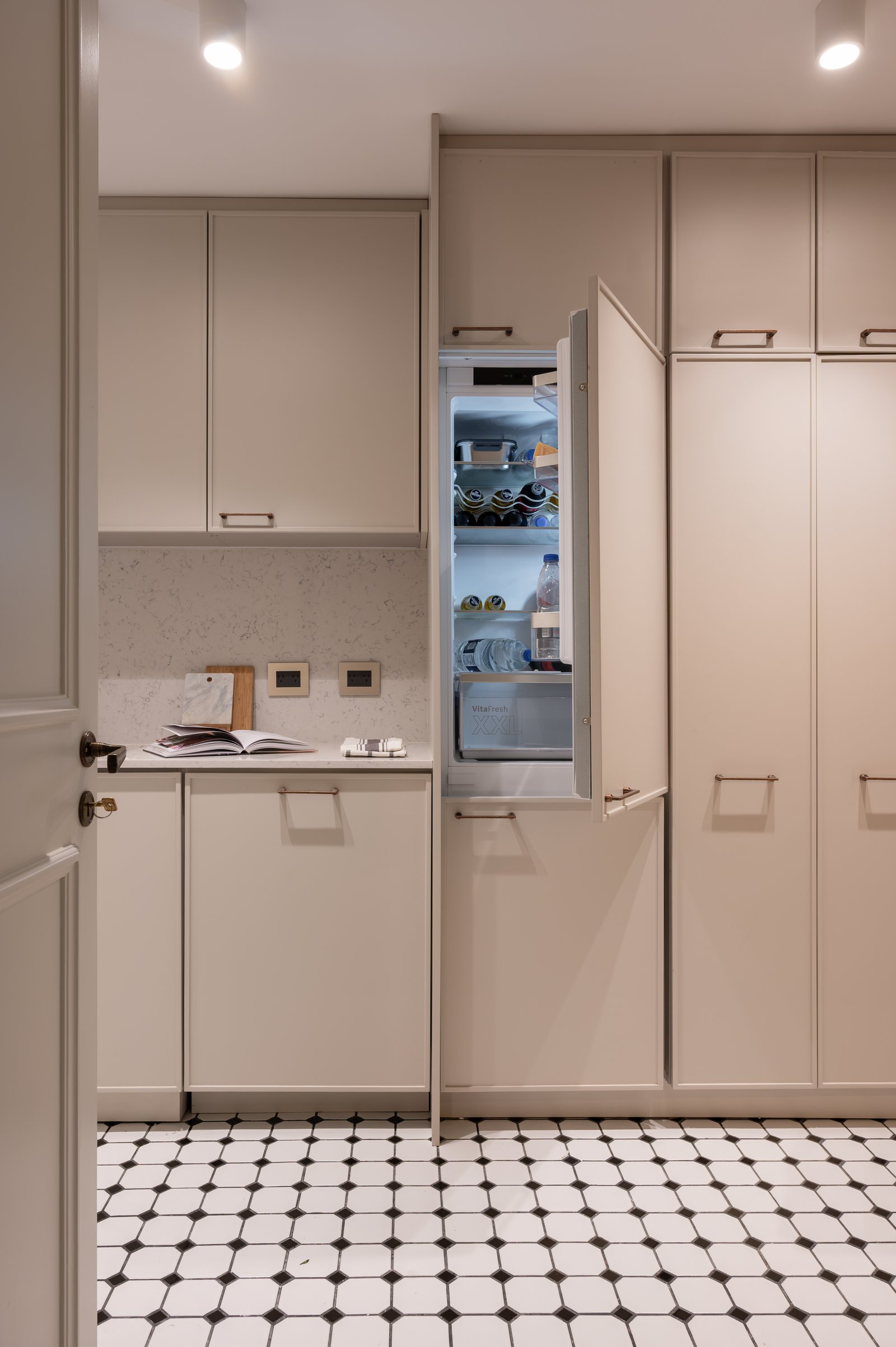 Cocina moderna beige con heladera integrada y piso damero — proyecto LIBERTADOR DANDY, por AB ARQUITECTURA, en Recoleta